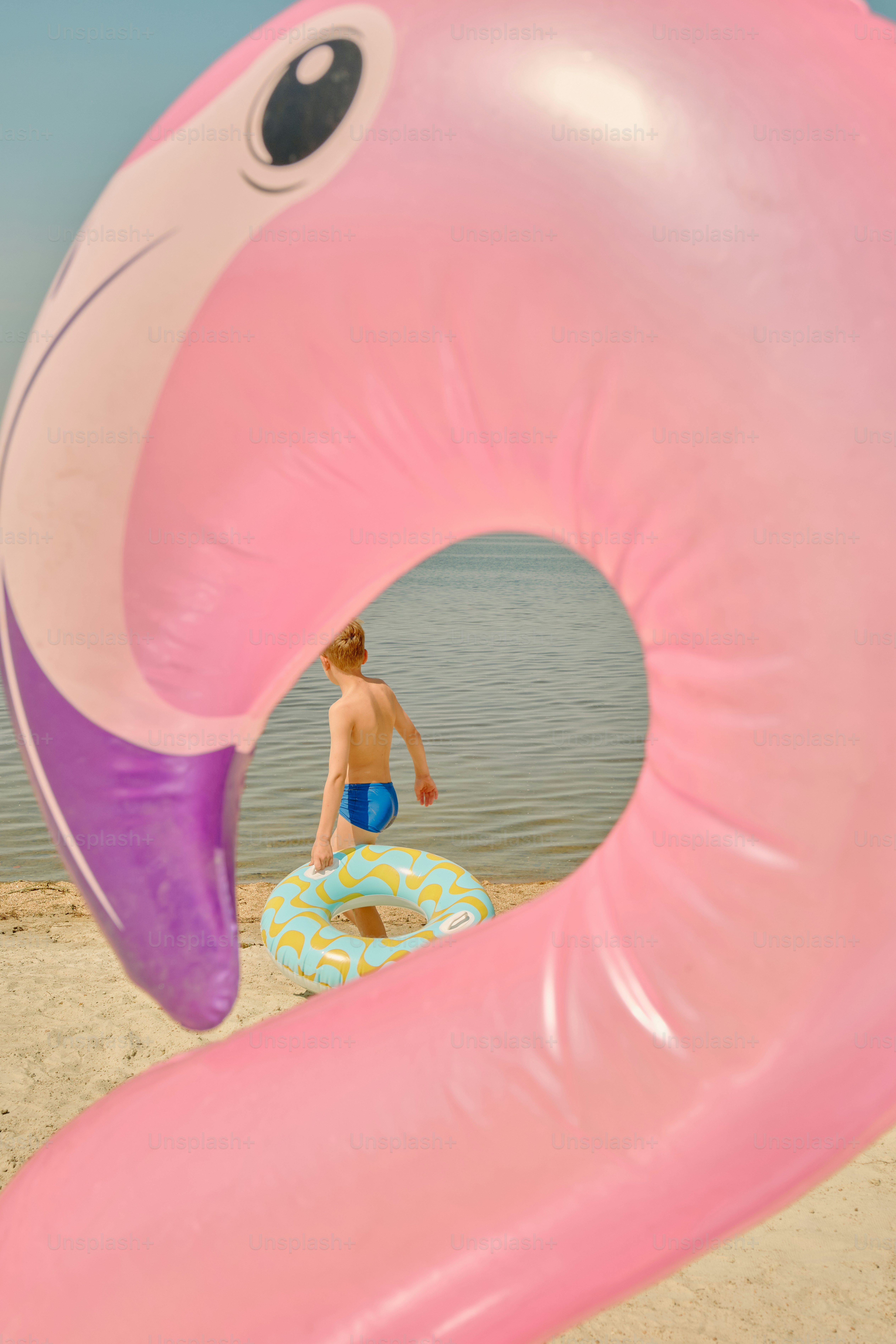 A boy walks towards the water through the float
