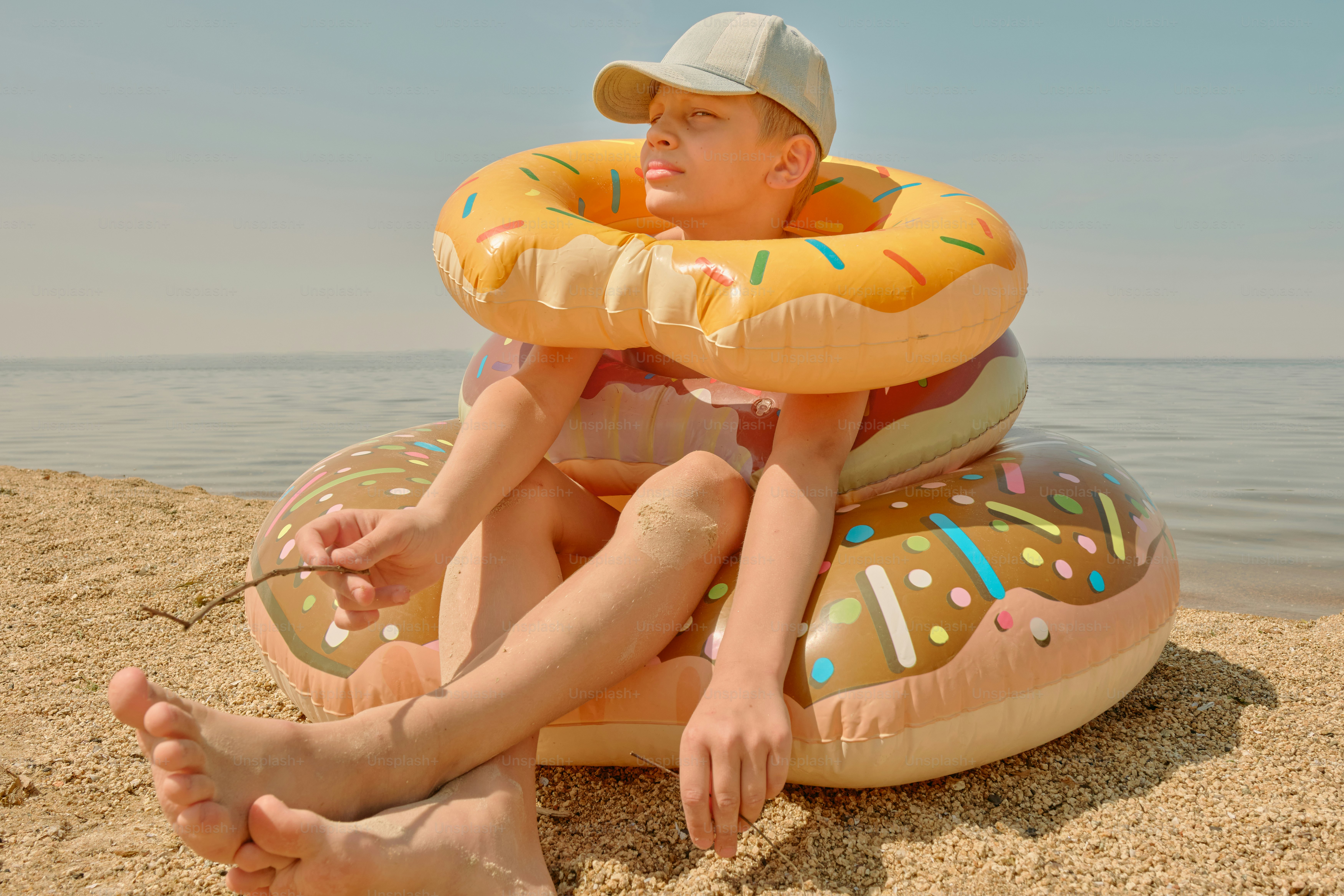 Man on a beach with inflatable donuts