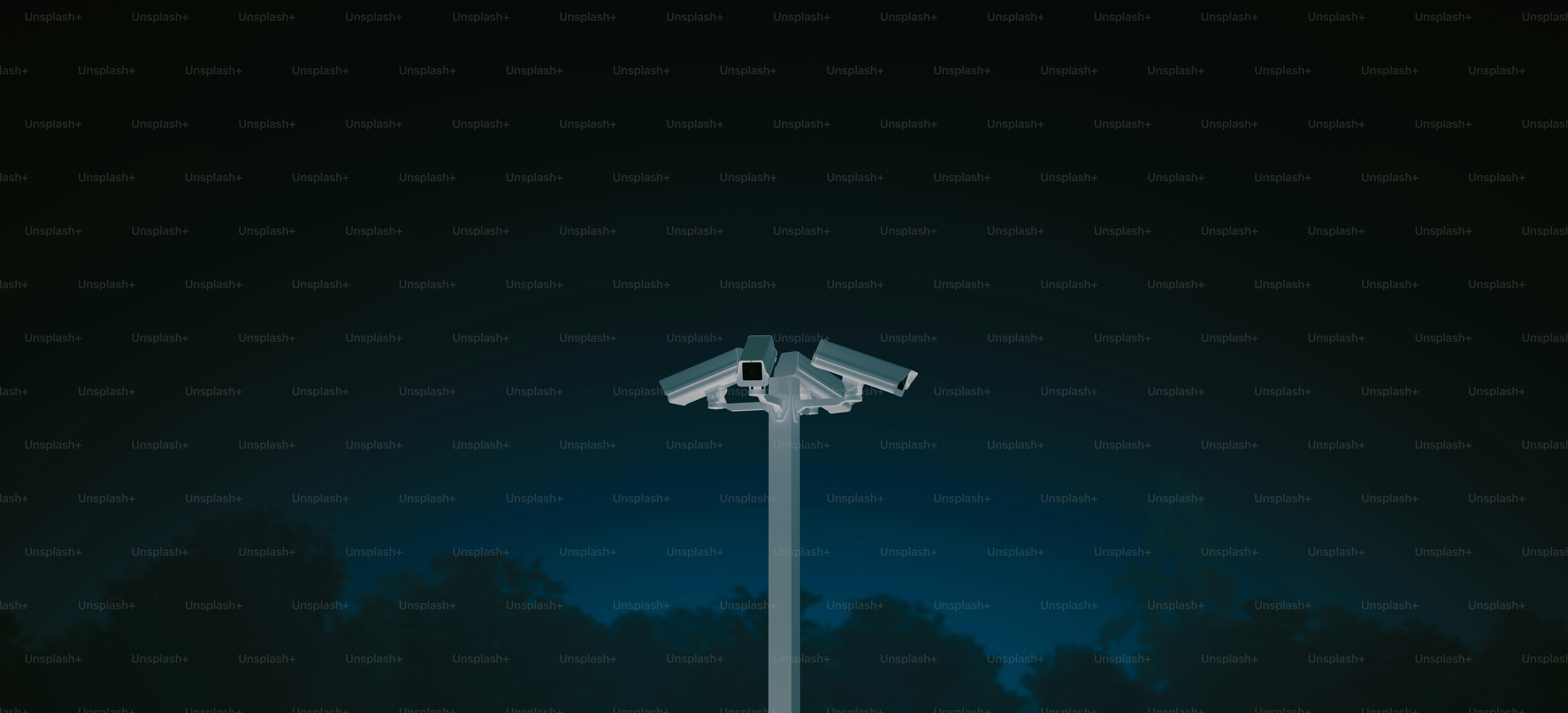 Surveillance cameras on a pole against dark sky.