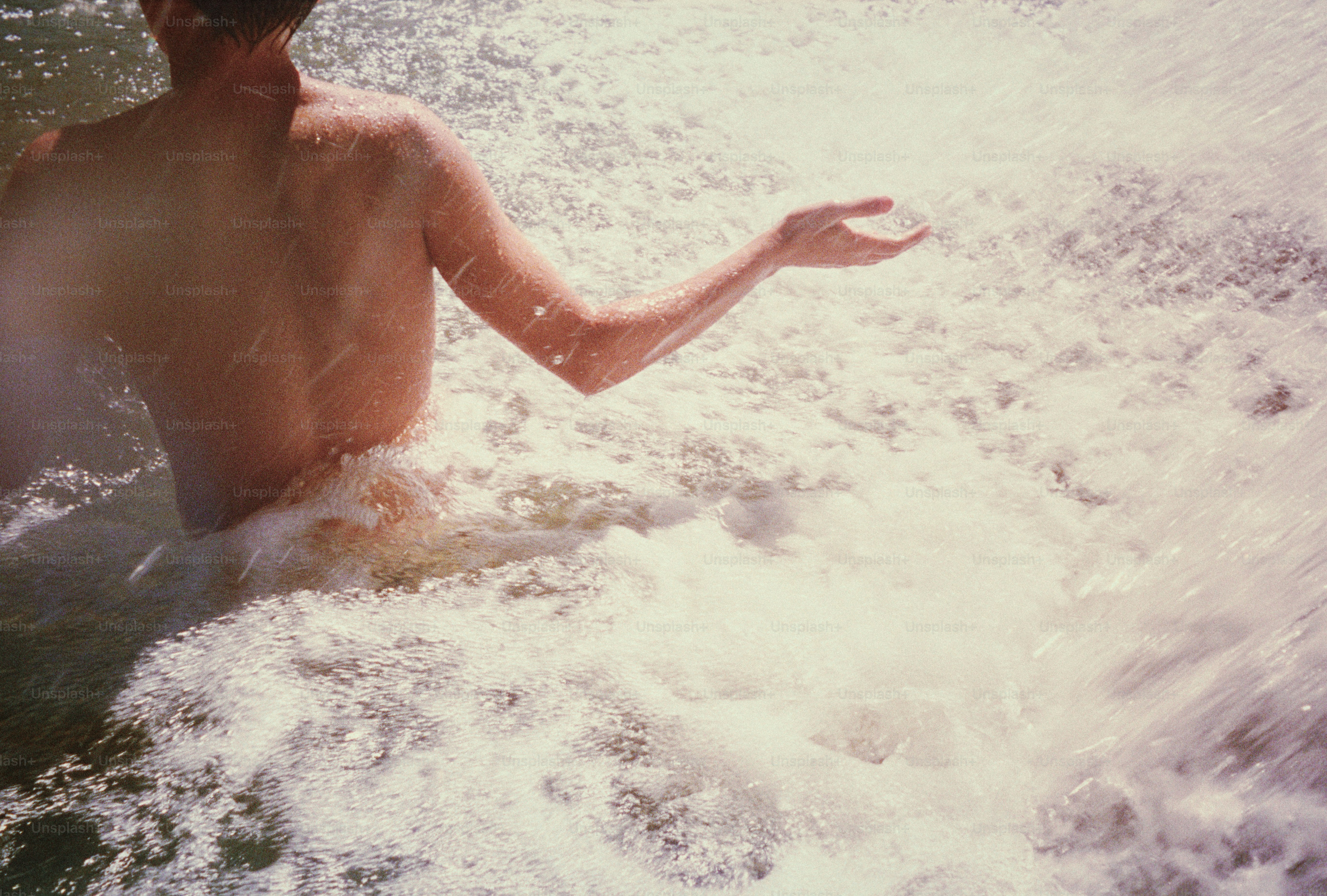A person enjoys water, surrounded by splashes.