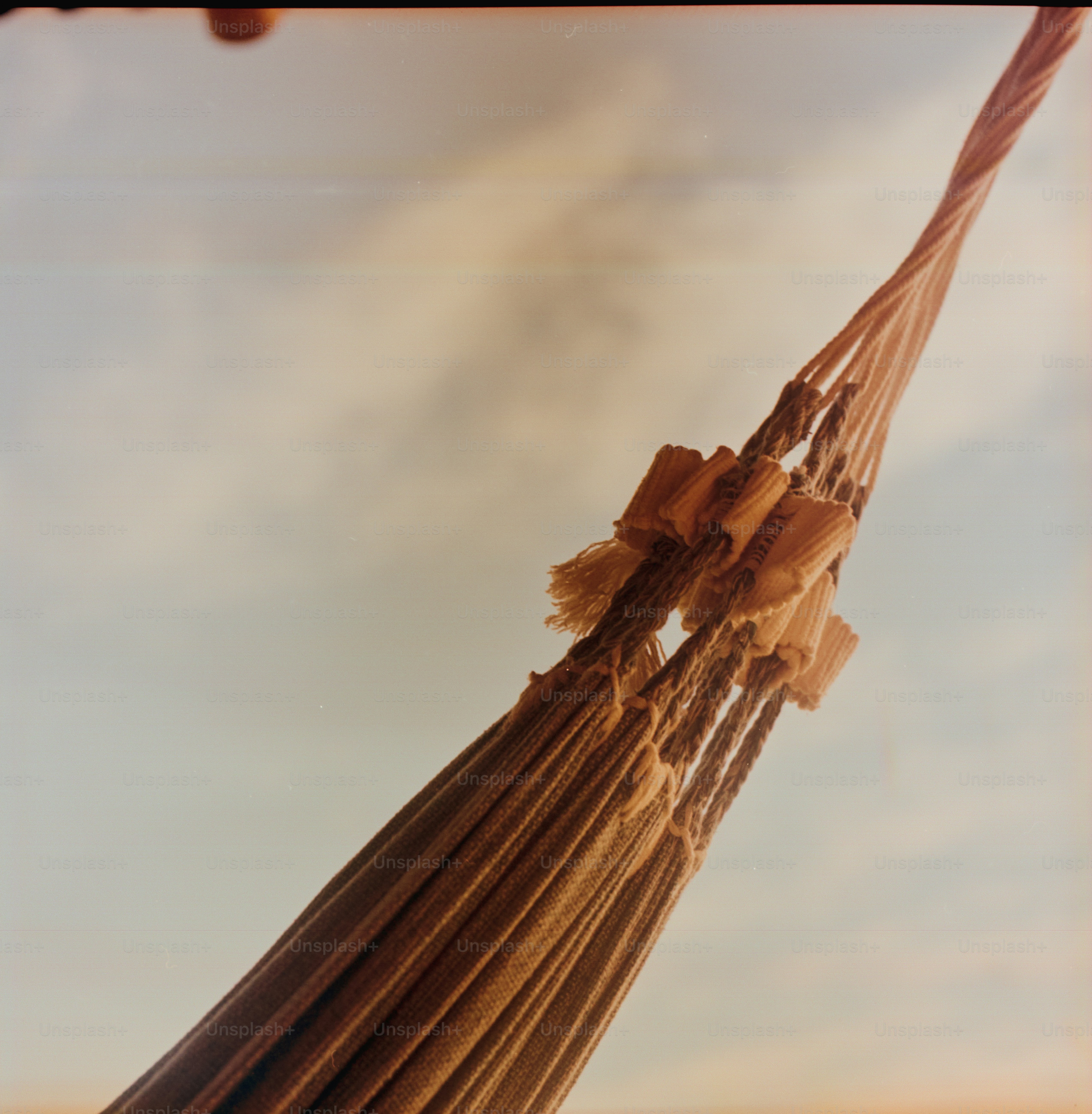 Una hamaca cuelga contra un cielo brillante y nublado.