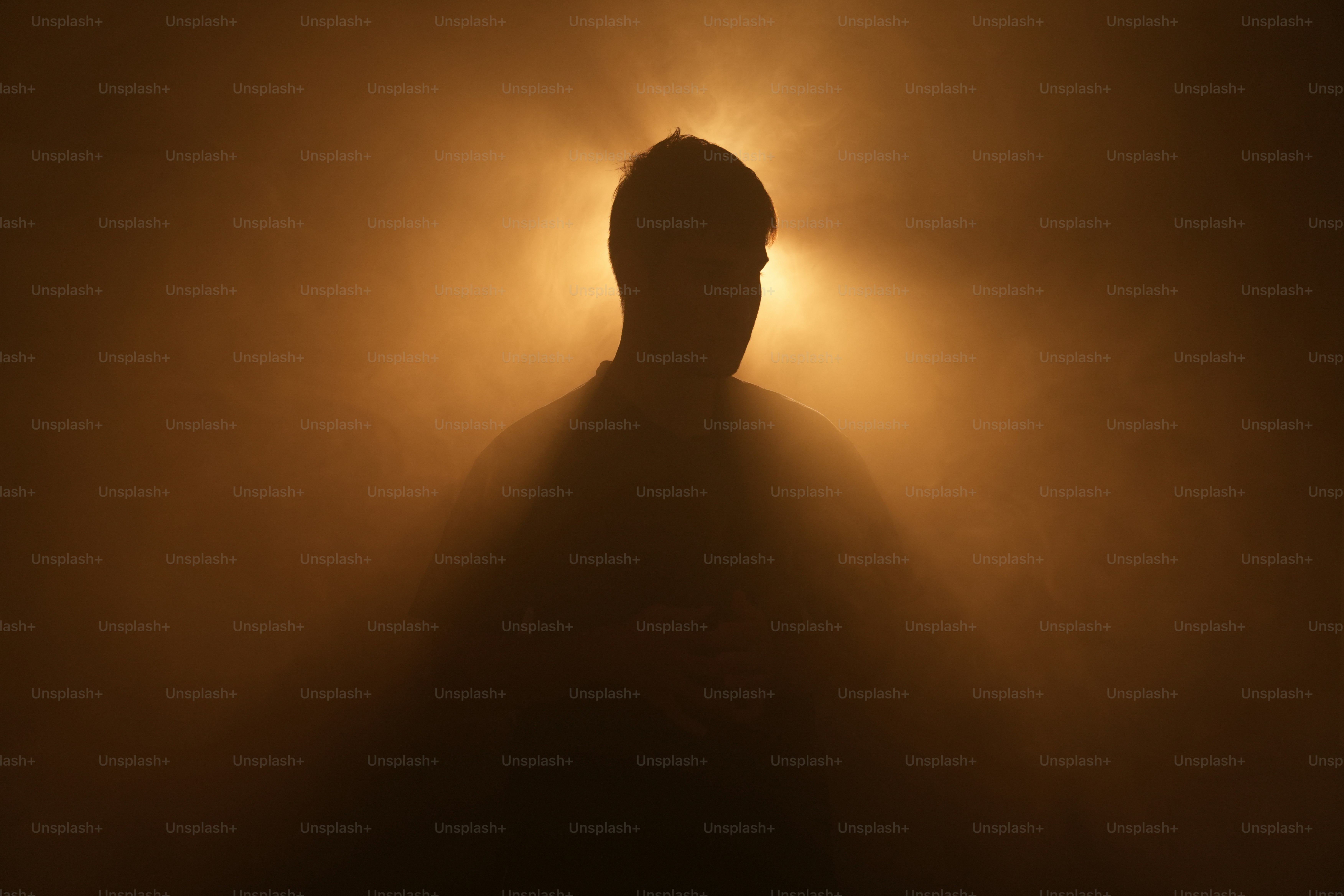 A silhouette stands in front of a bright light.