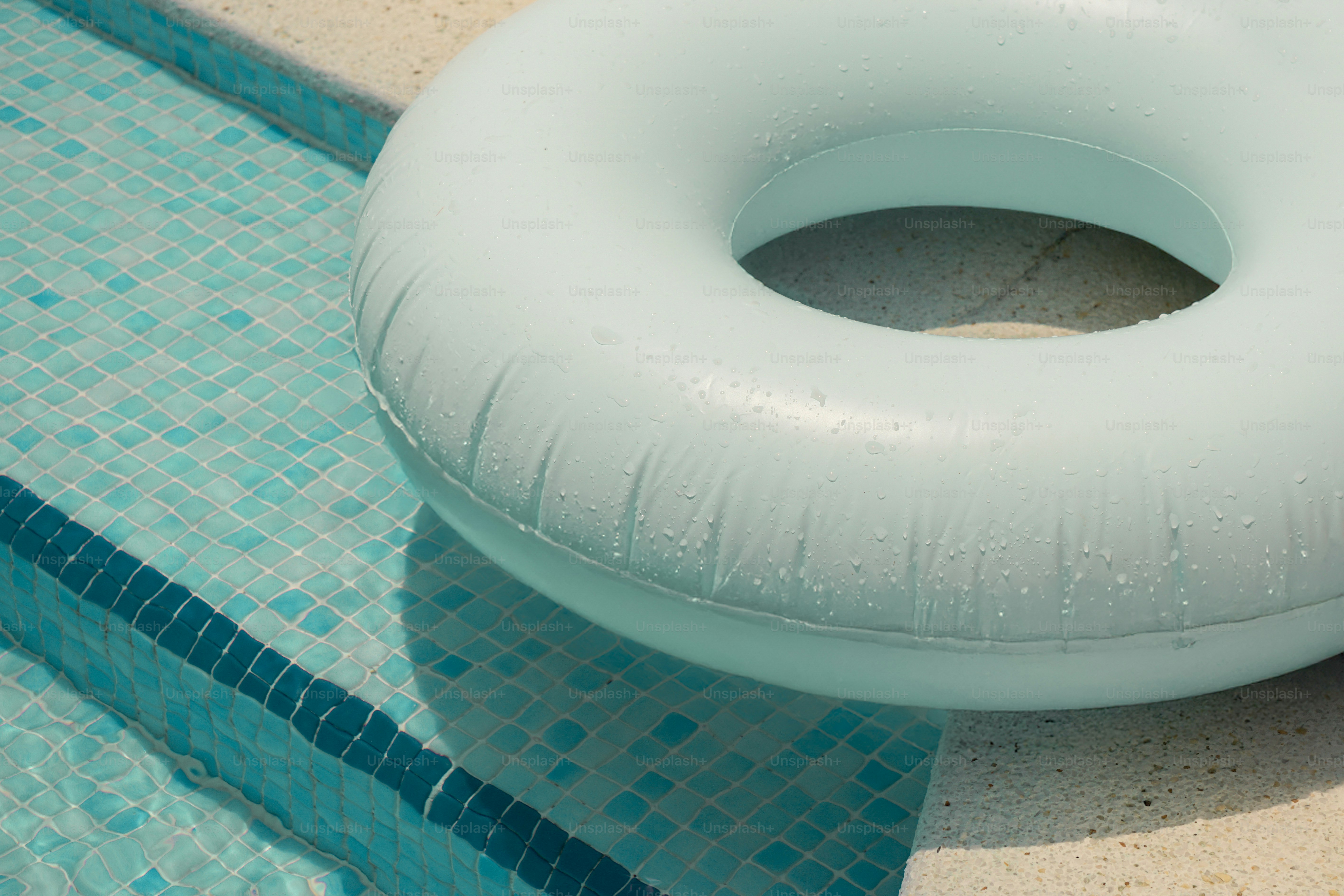 A blue pool float rests beside a pool.