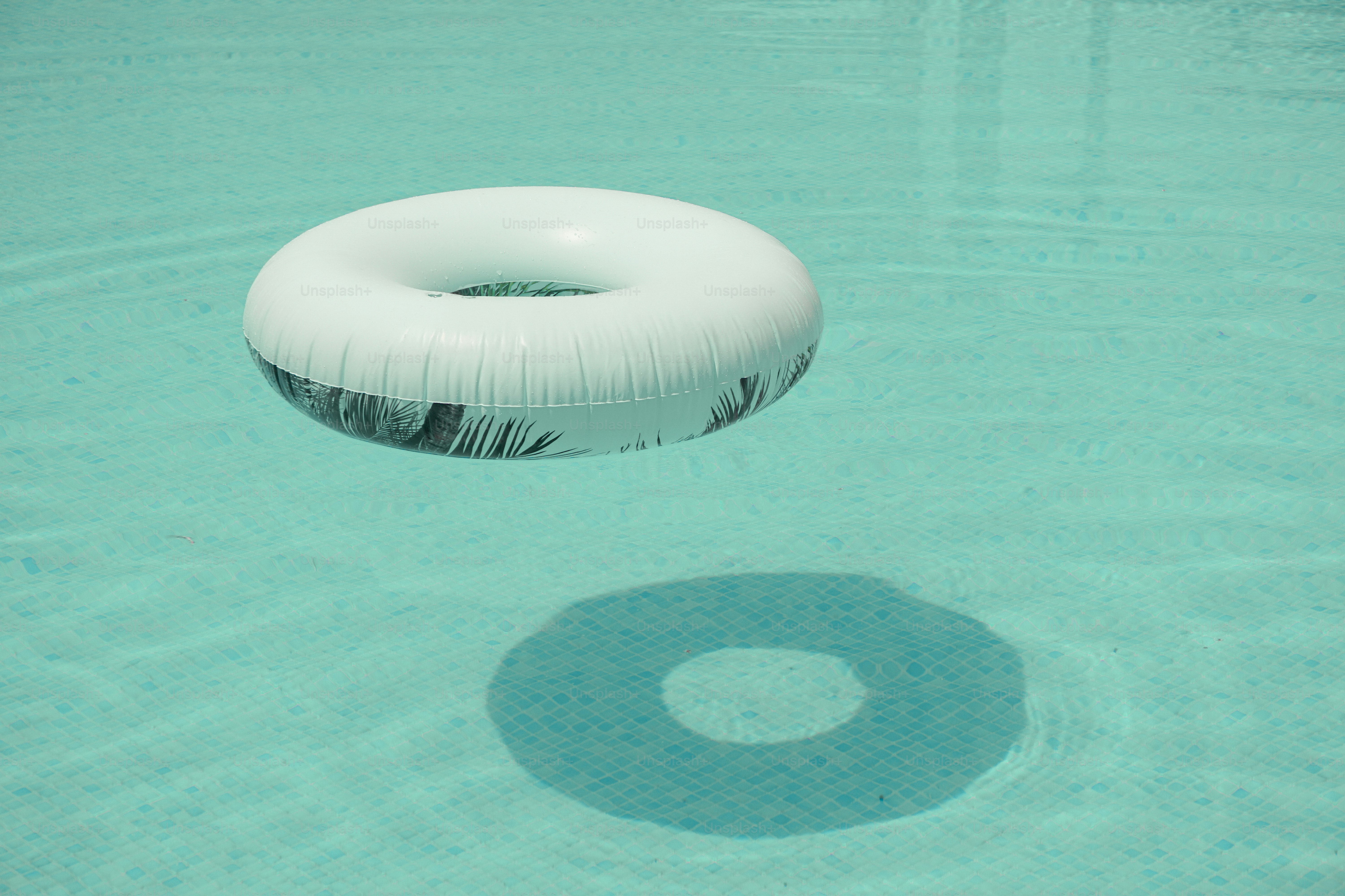 A white pool float rests on water.