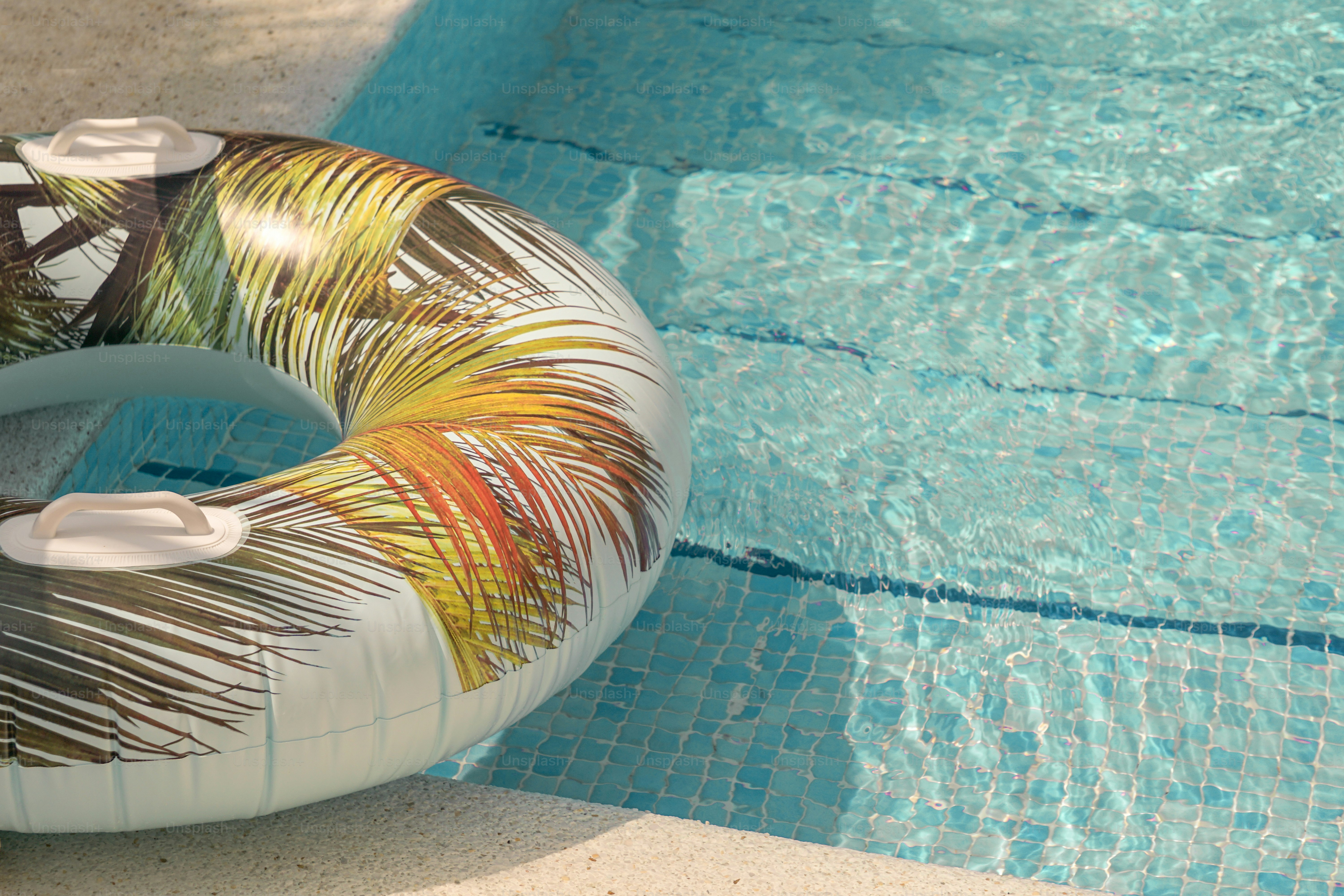 A colorful float rests in the cool, blue pool.