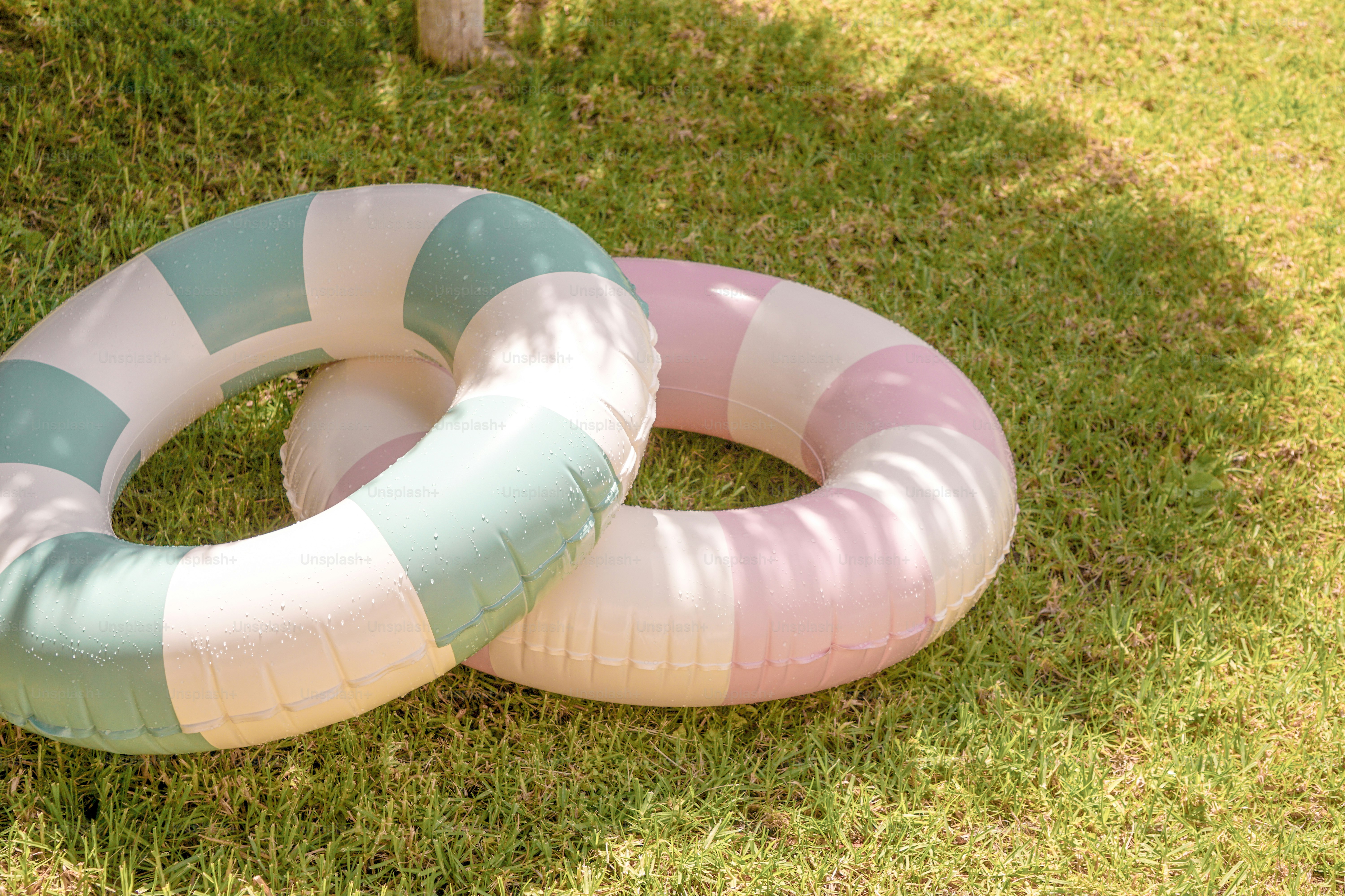 Two colorful inflatable rings rest on green grass.