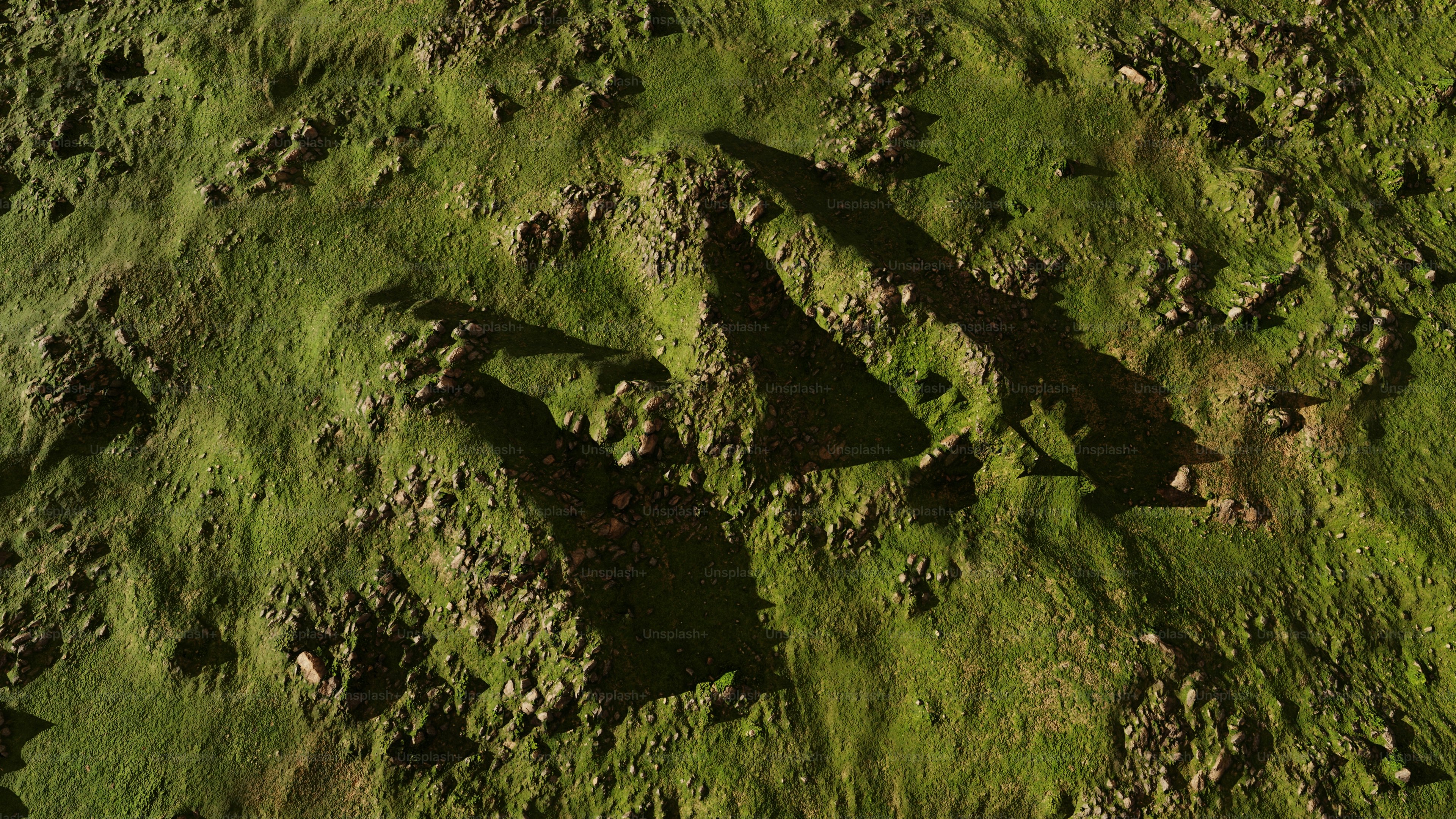 Shadows fall on a grassy, uneven surface. photo – Texture Image on Unsplash, image size:3000x1688