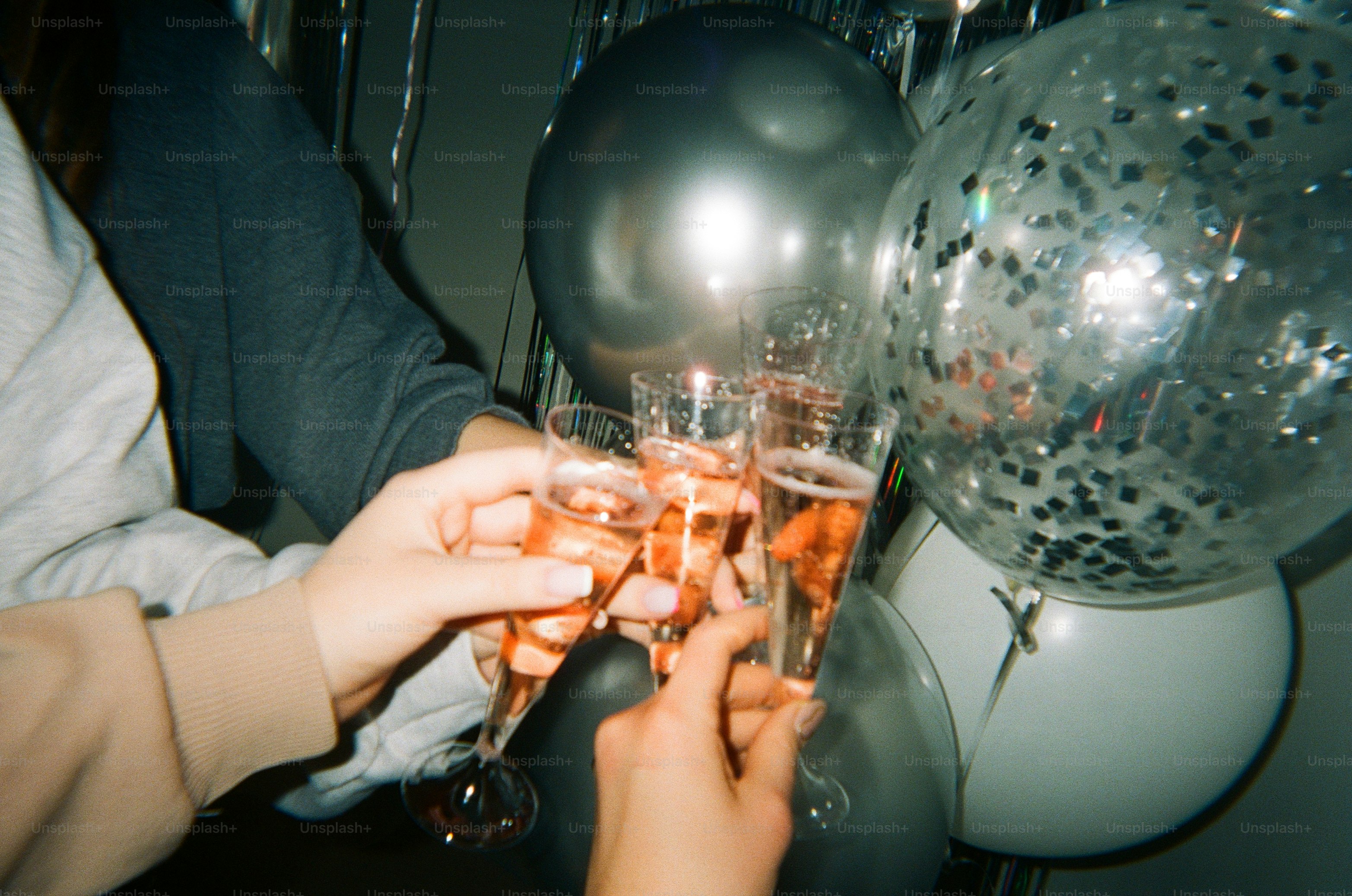 People are toasting champagne with balloons.