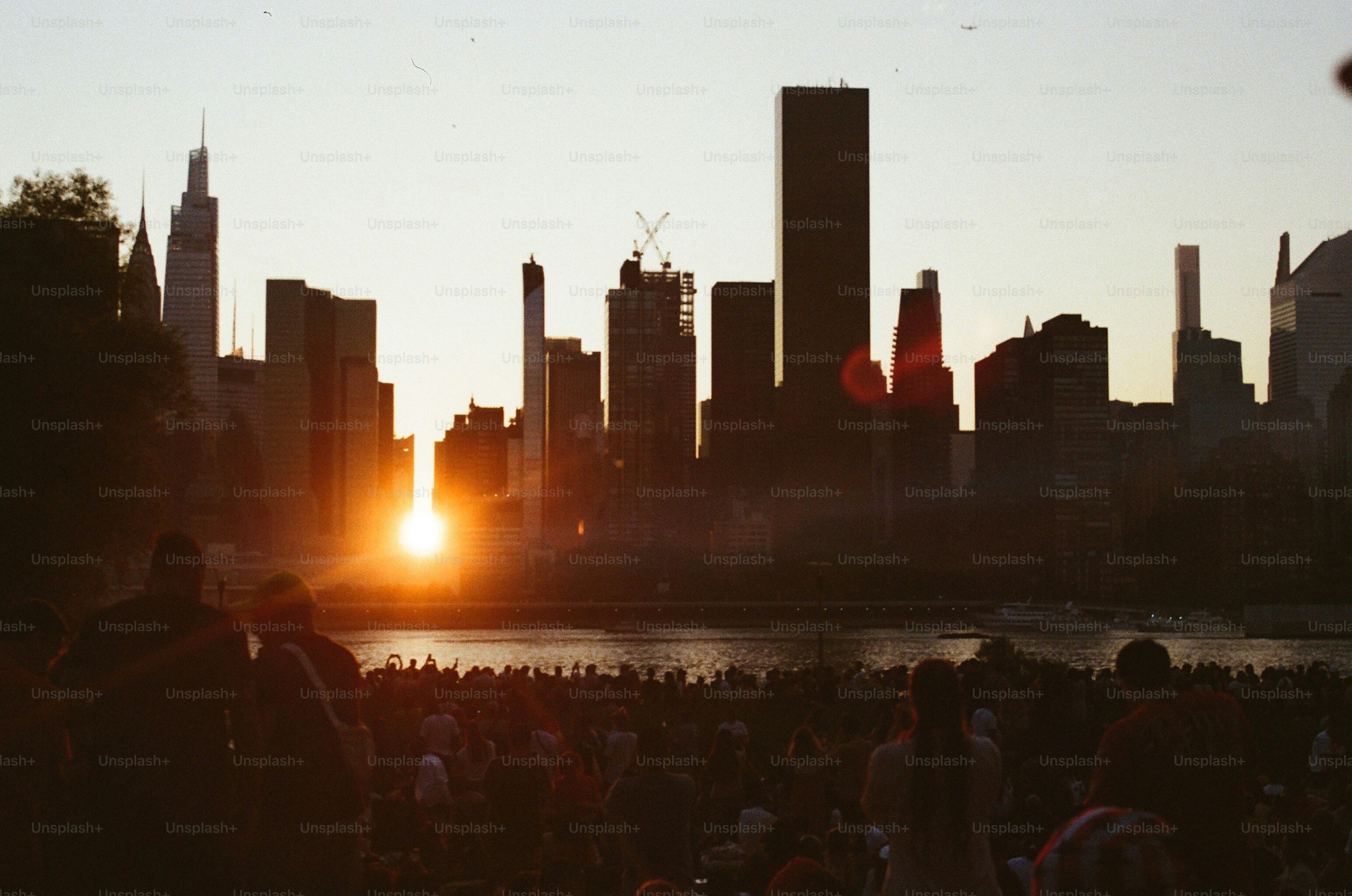Sunset over the skyline and crowd of people.
