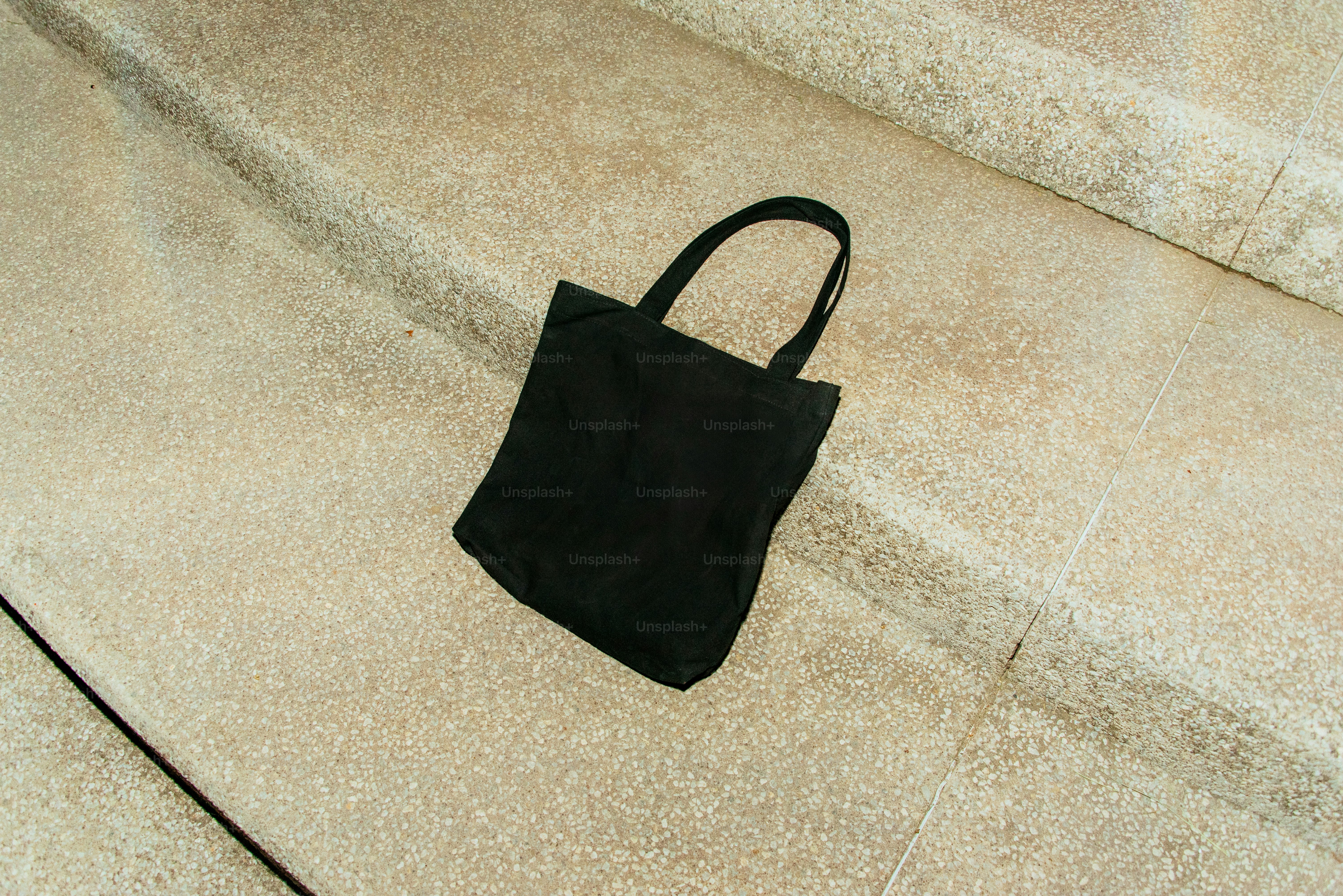 A black tote bag sits on a staircase.