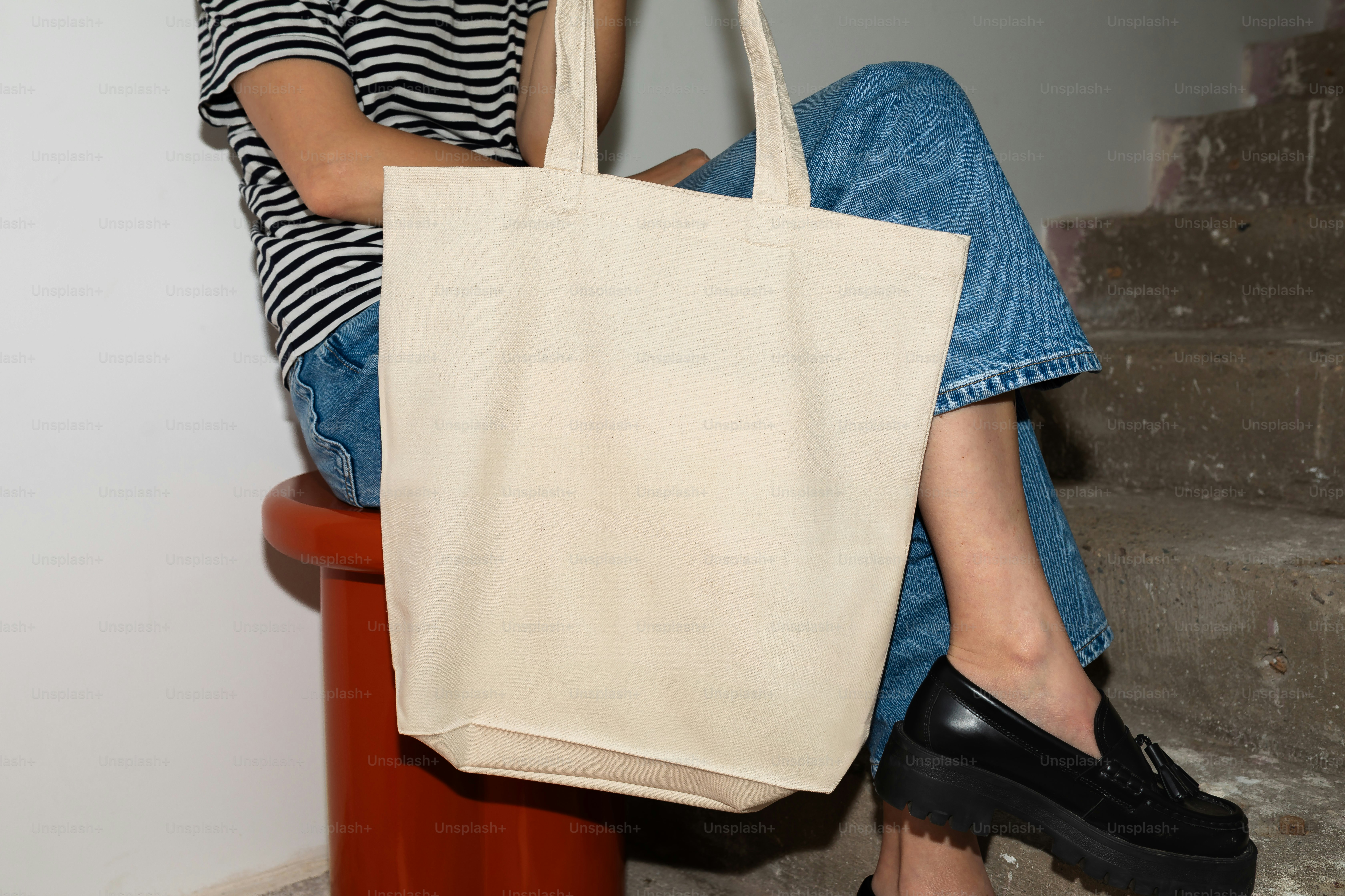 A person holds a plain tote bag.