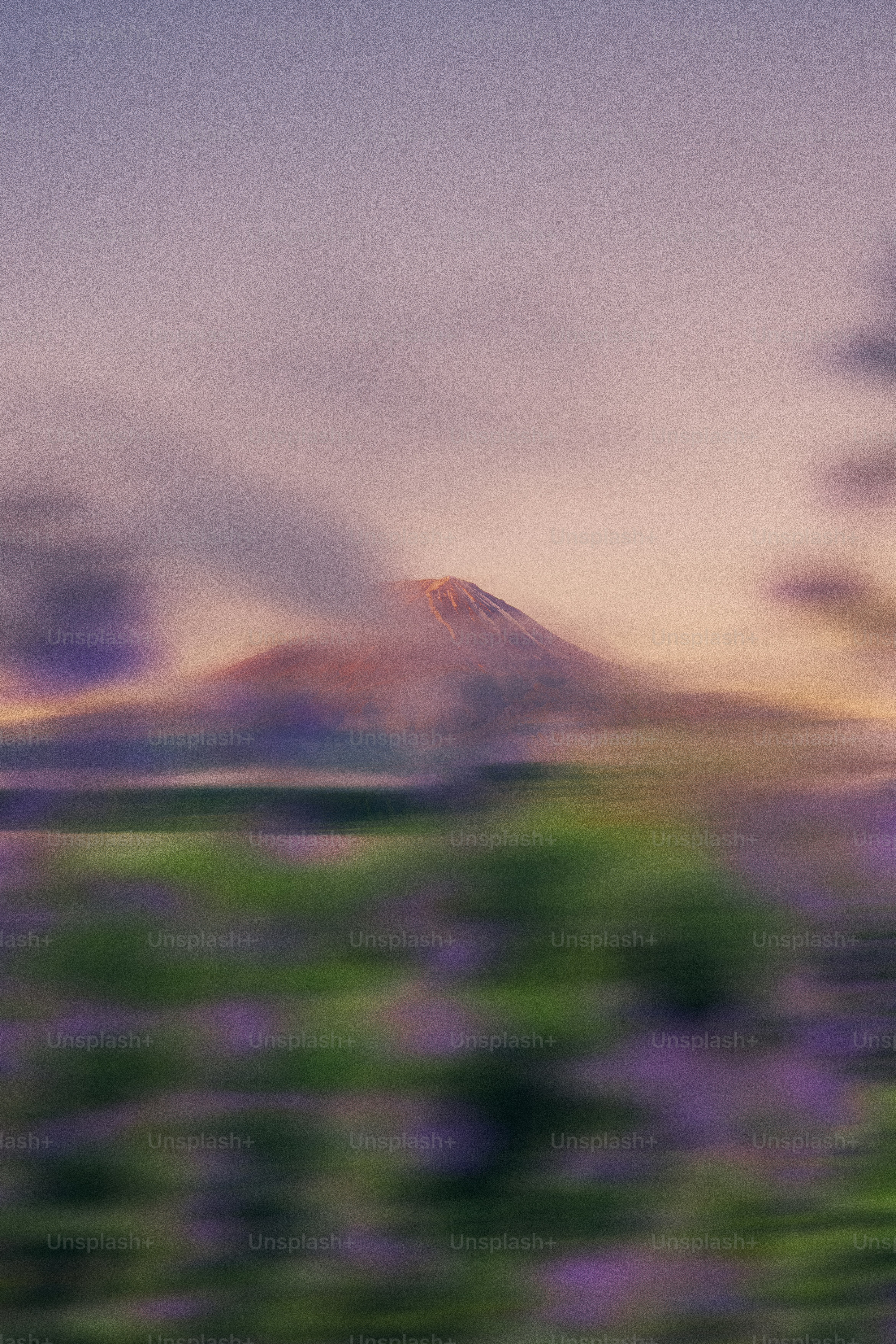 A mountain peaks through clouds.