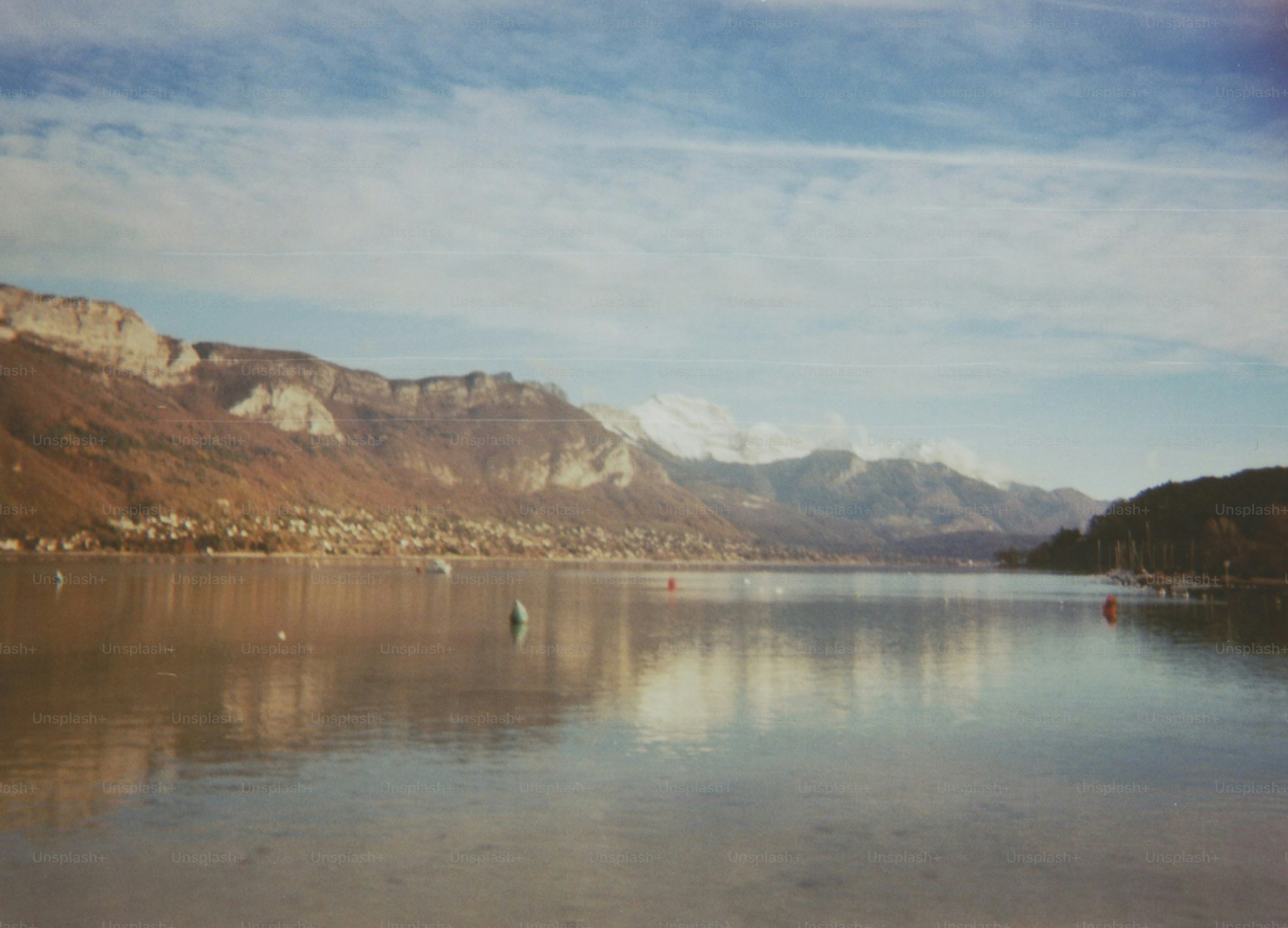 Las montañas y el lago se reflejan bajo un cielo brillante y soleado.