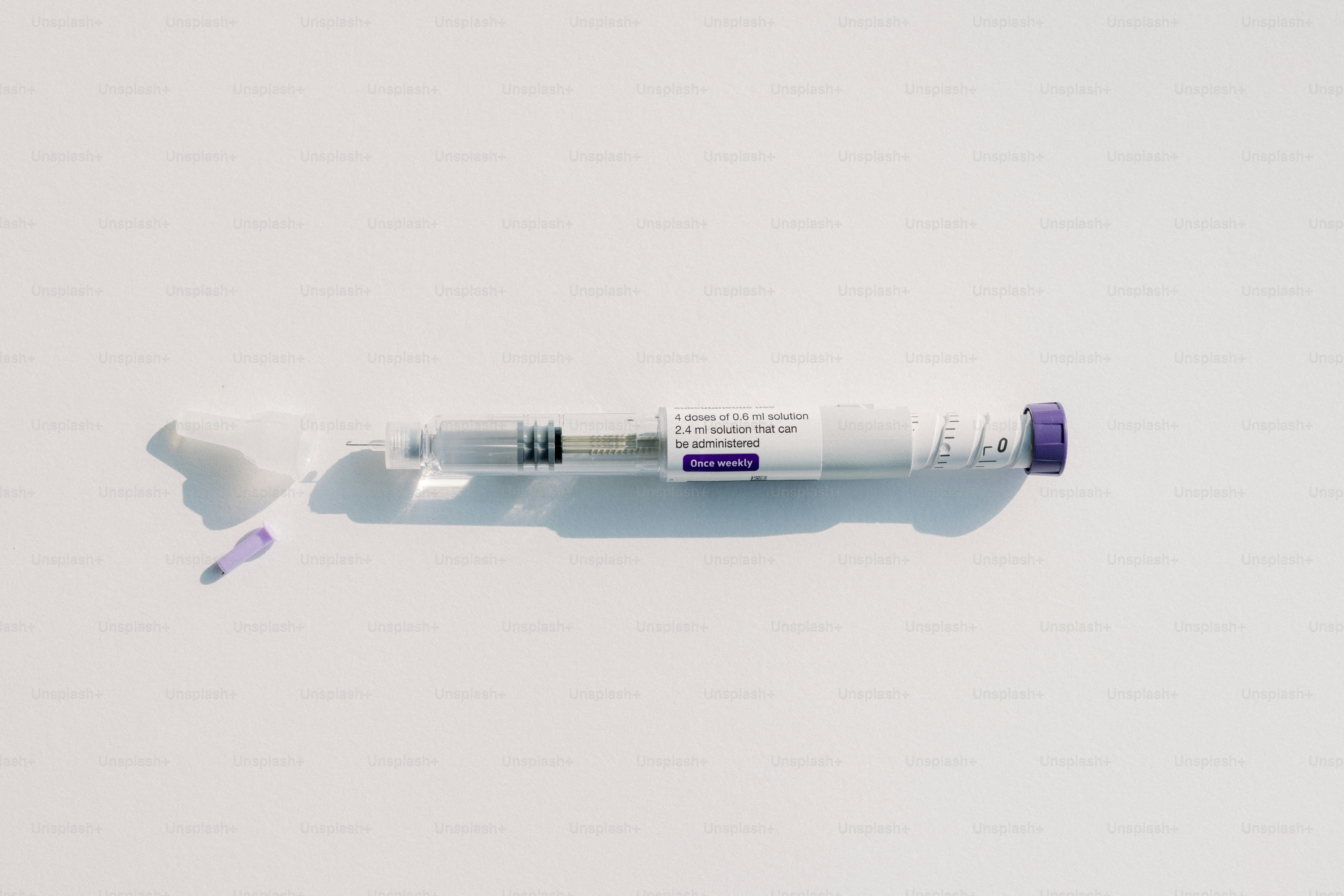 Esta es una posible leyenda: una jeringa de medicamento sobre una superficie blanca.