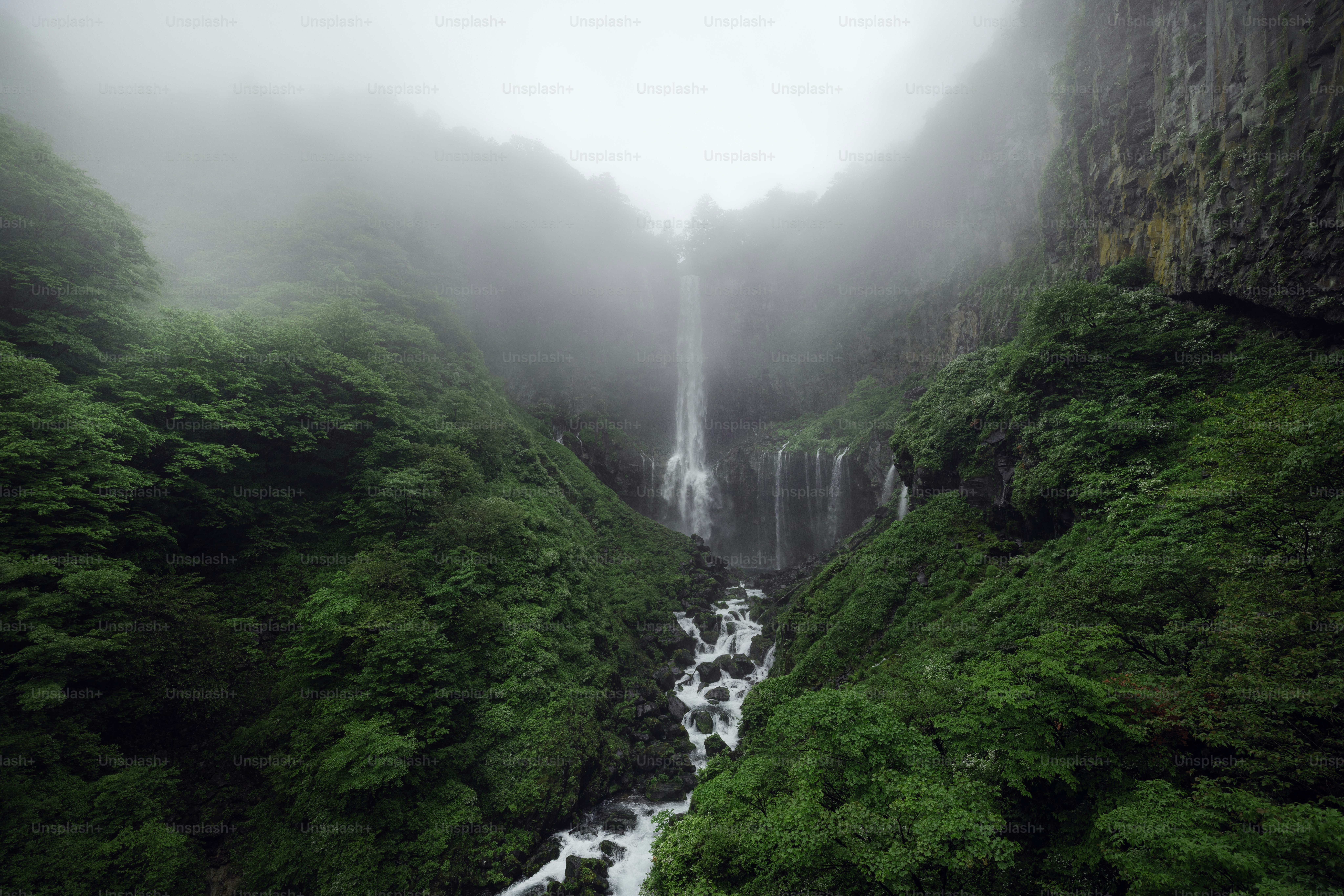 A majestic waterfall cascades through a green valley.