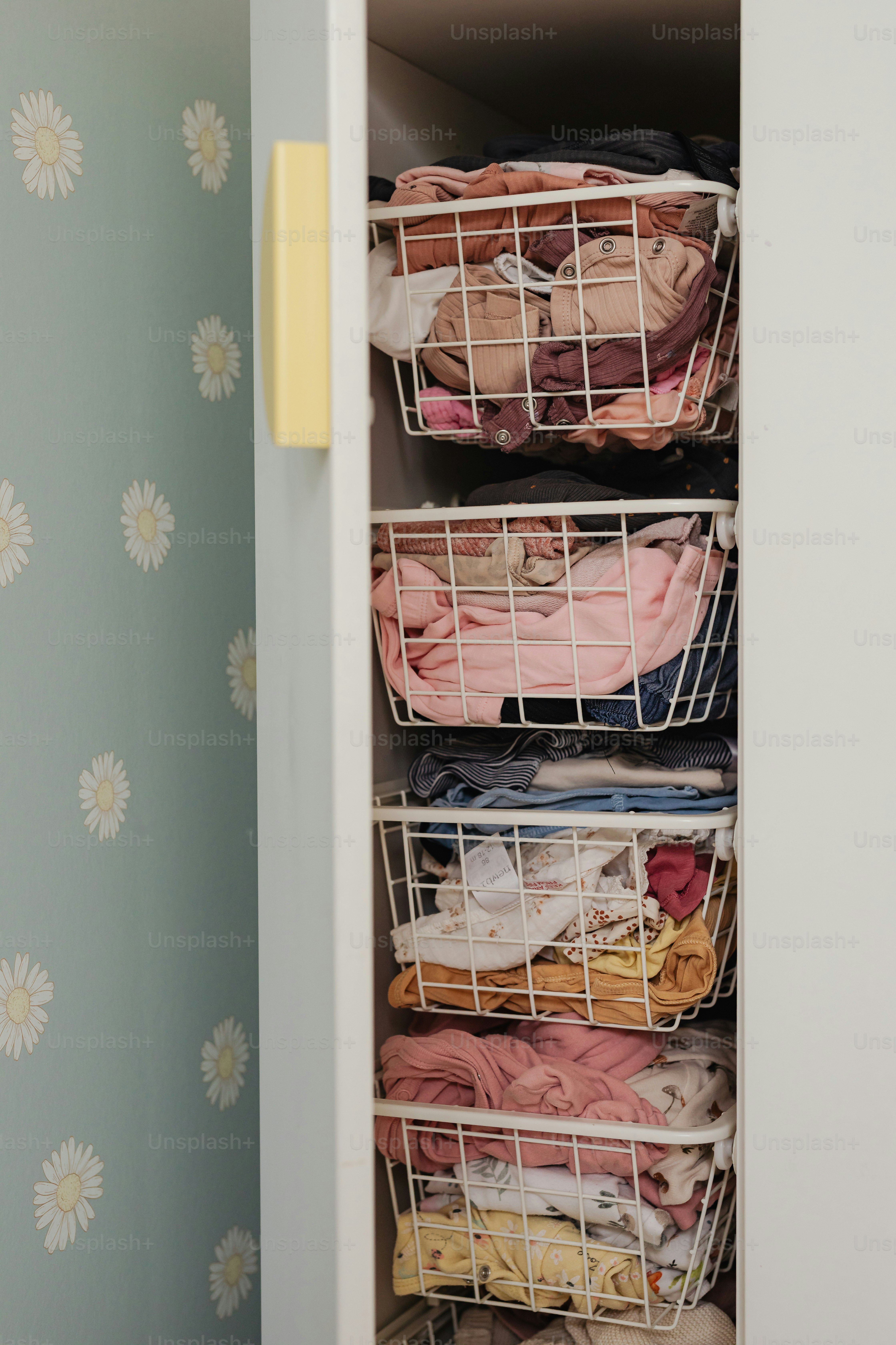 Clothes are stored in organized wire baskets.