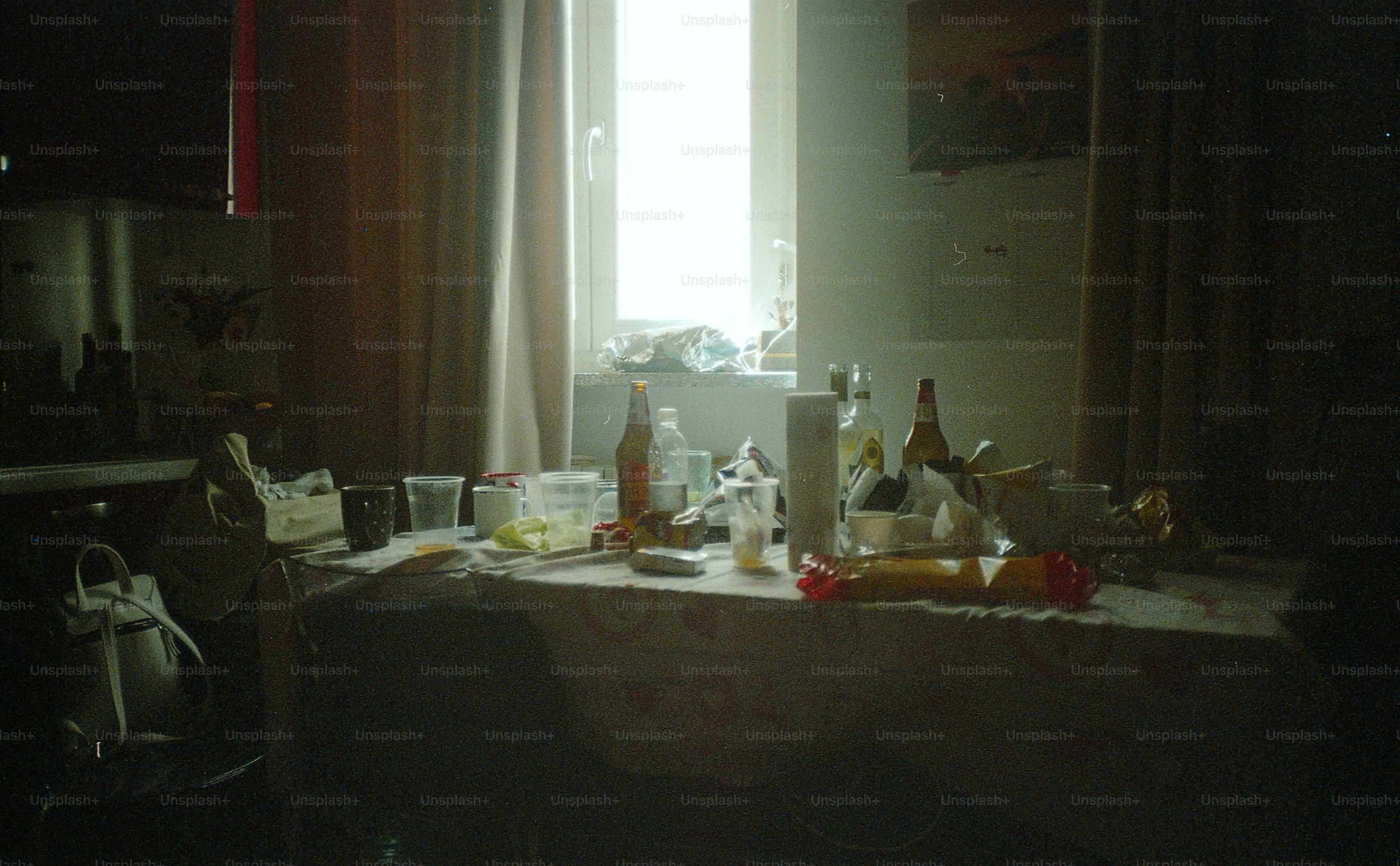 A cluttered table is lit by a bright window.