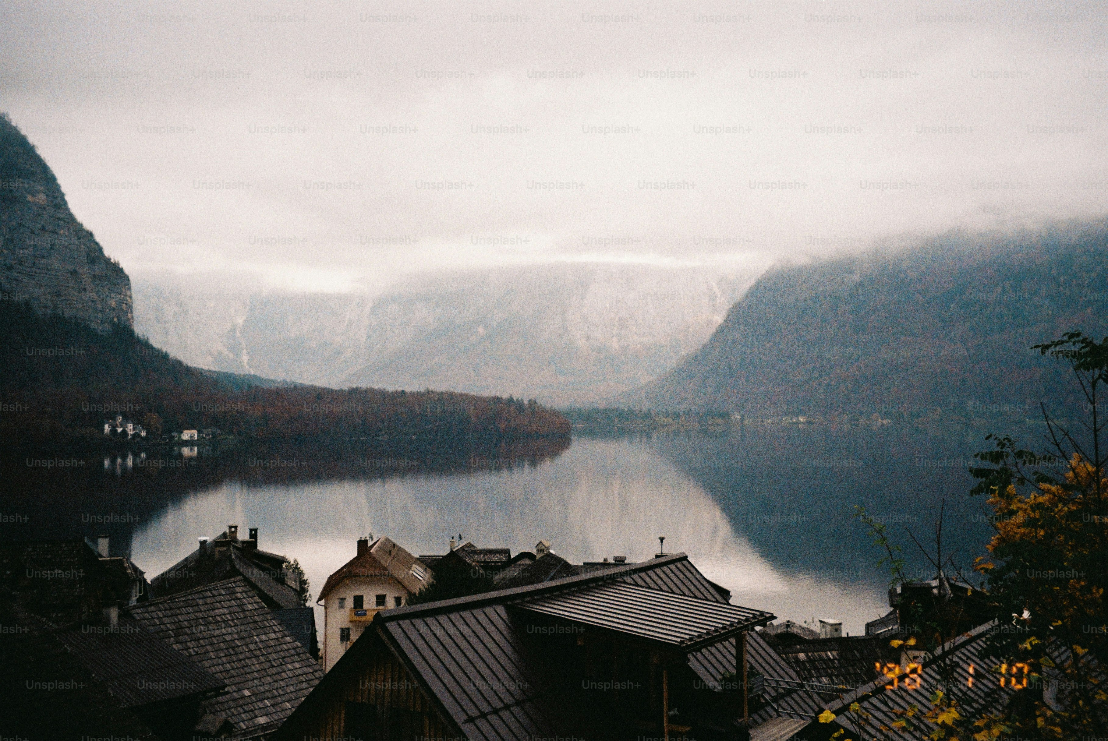 A peaceful lake reflects mountains and houses.