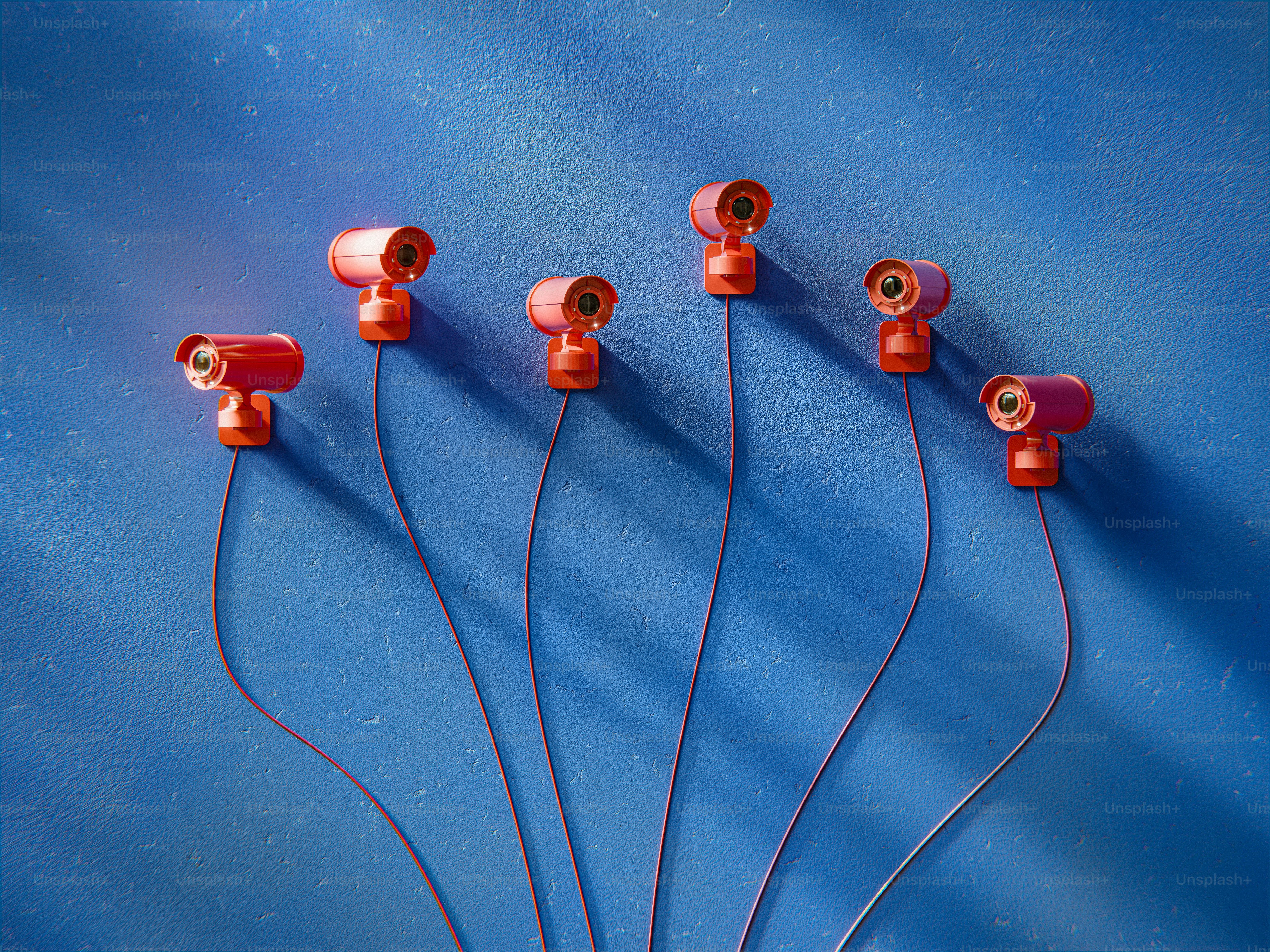 Surveillance cameras are arranged on a blue wall.