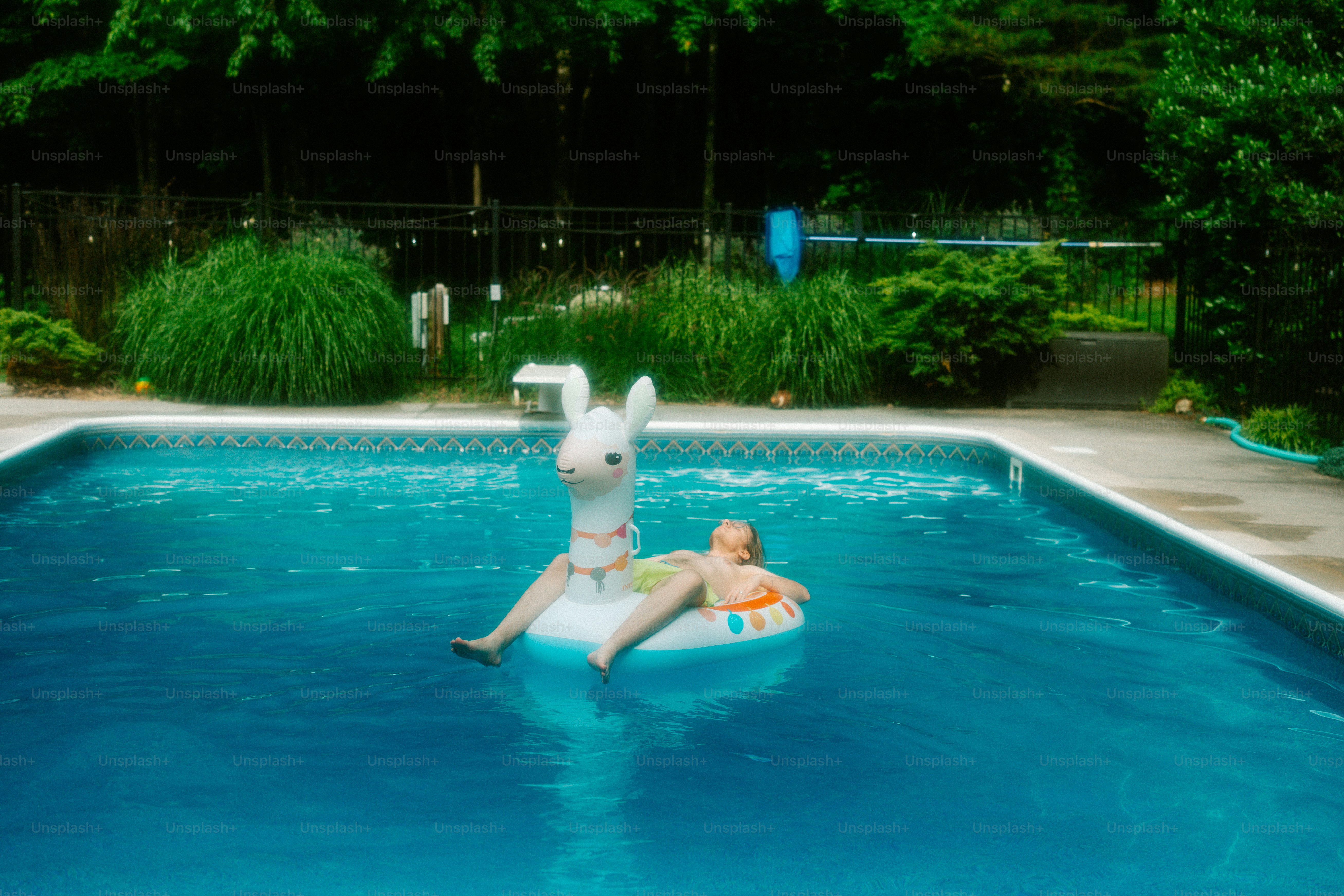 A child floats in a pool on a bunny float. photo – Summer fun Image on ...
