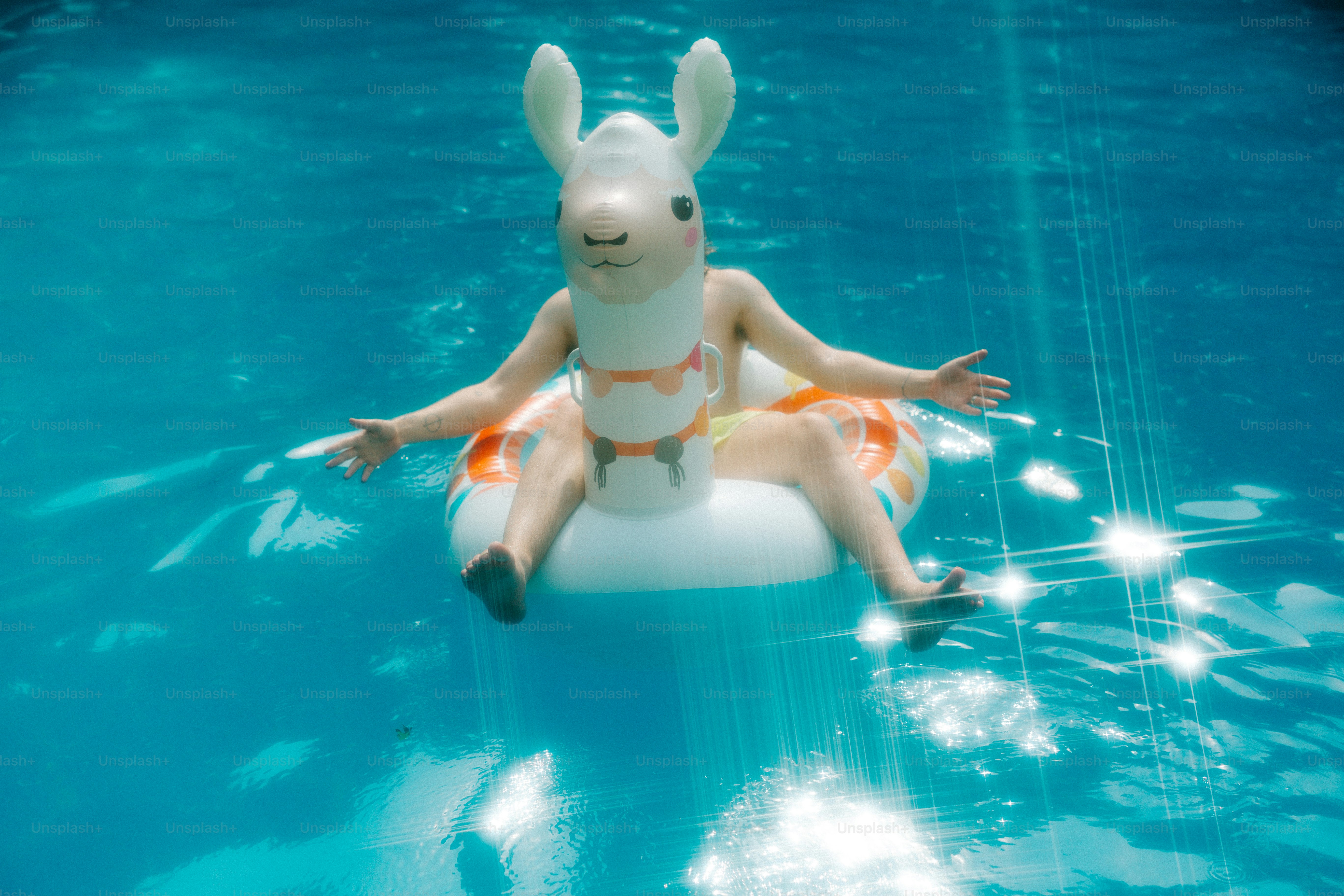 A child floats in a pool on a bunny float. photo – Summer fun Image on ...