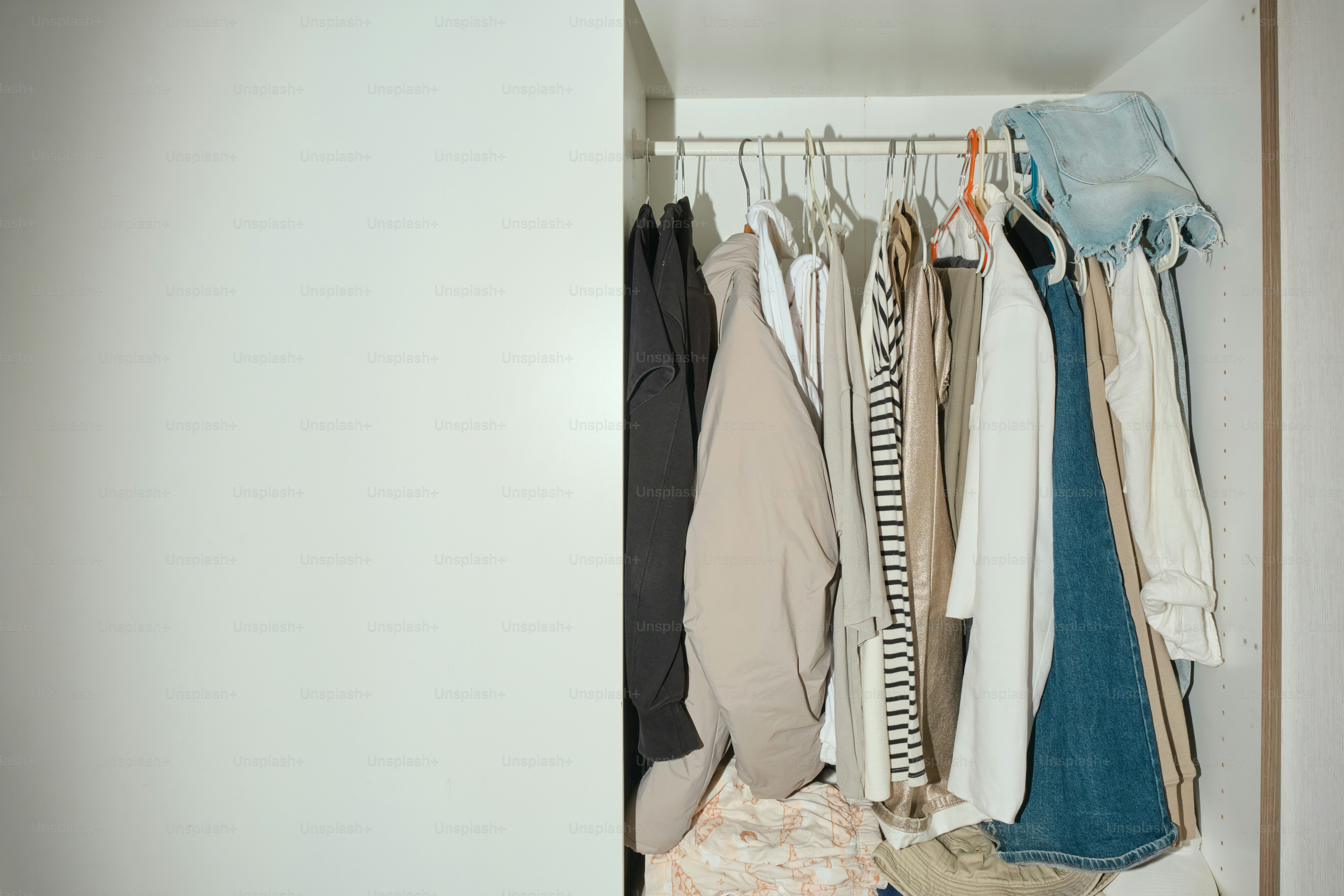 Clothes hang in a closet.