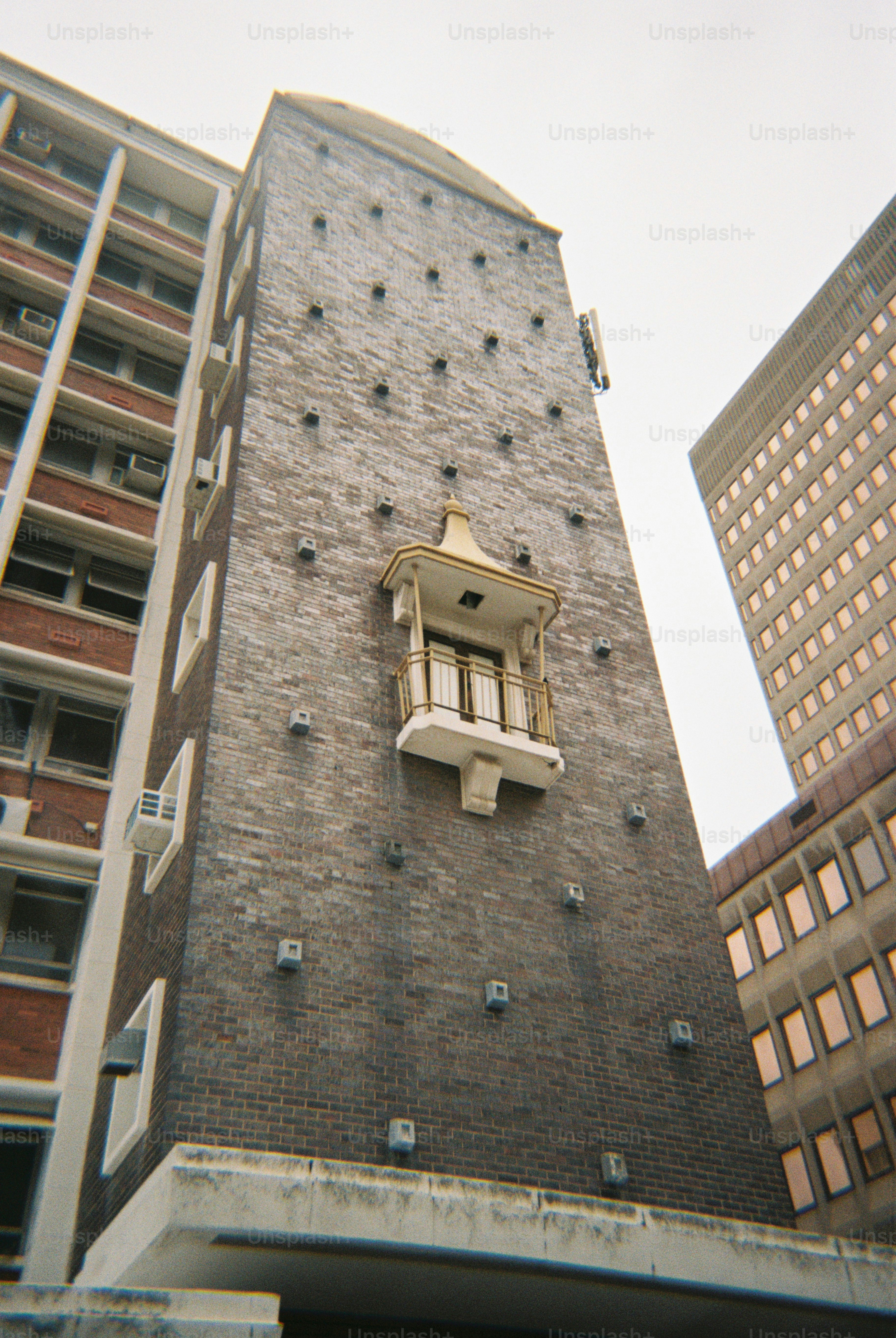 A unique brick tower with balcony.