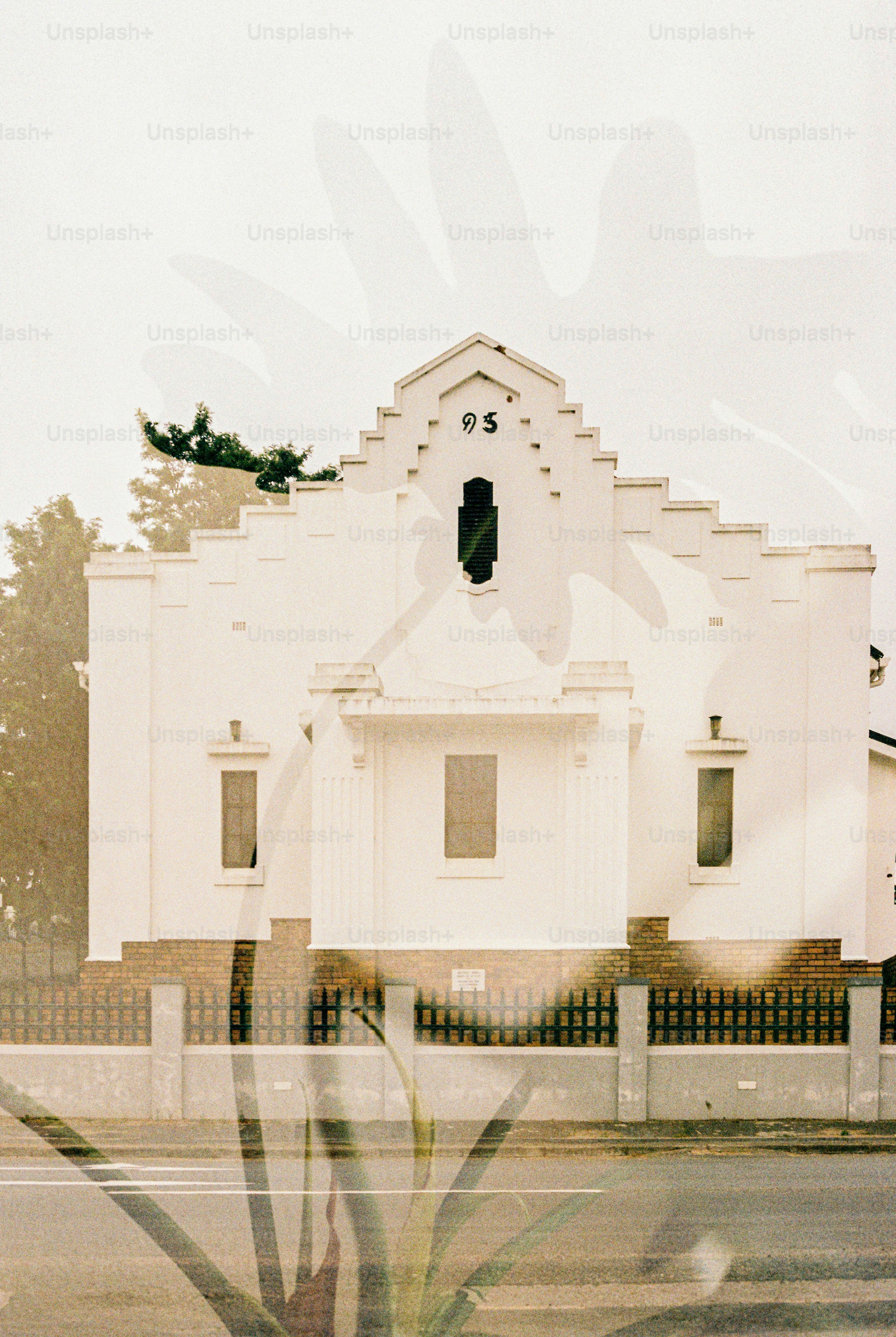 A white building is shown with a plant overlay.