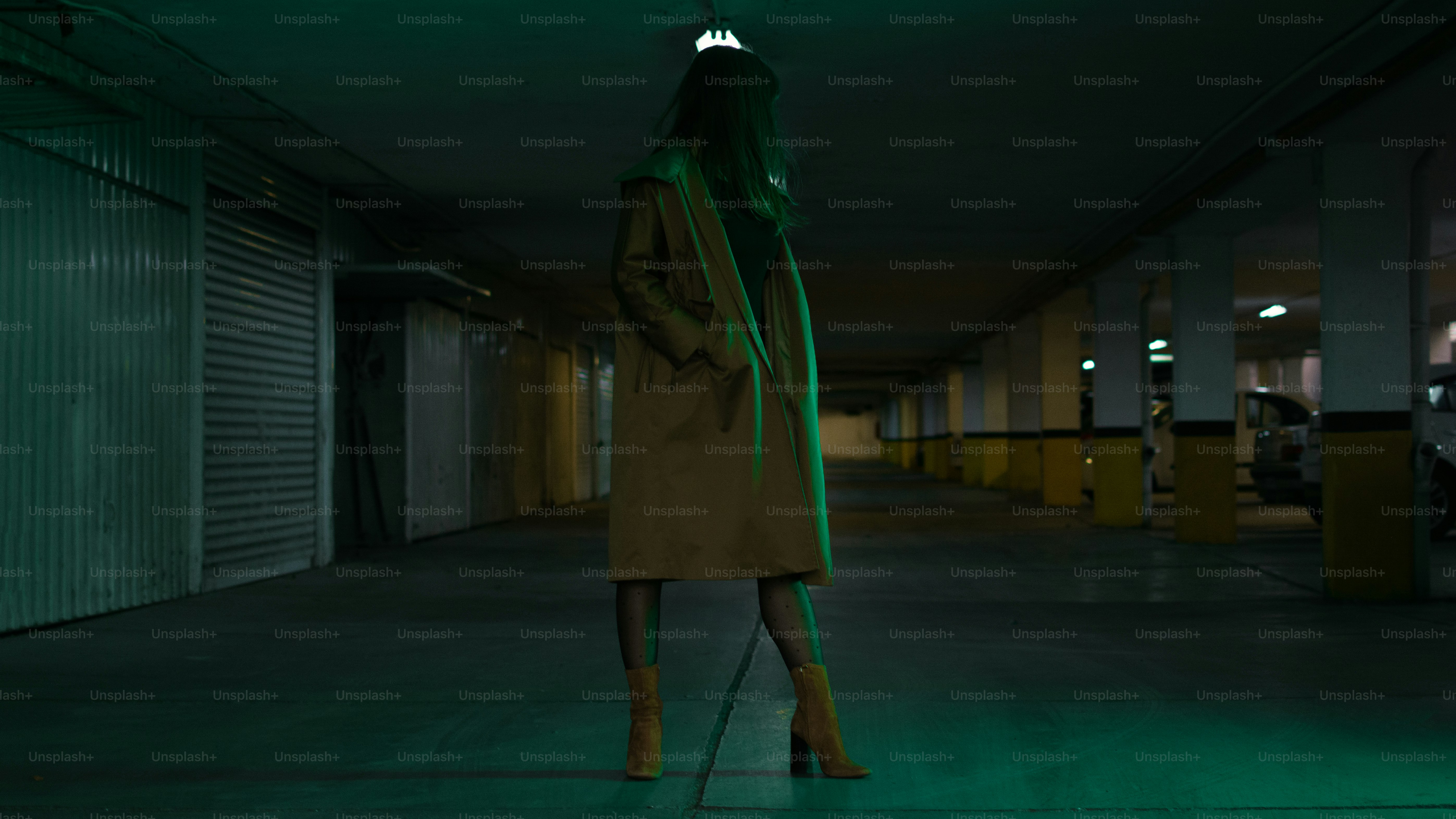 Mujer posando en un estacionamiento con poca luz.