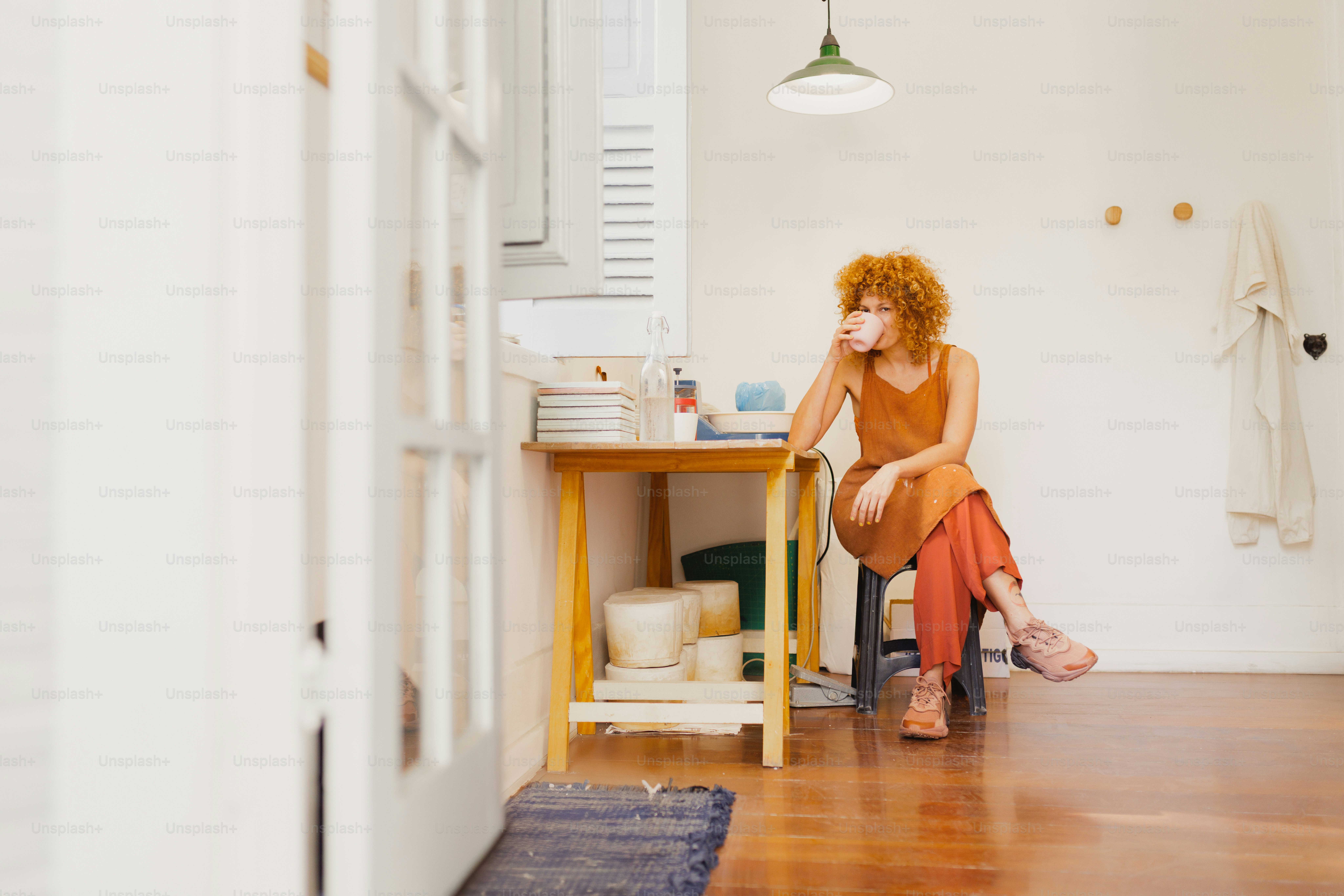 A woman sits in a room, deep in thought.