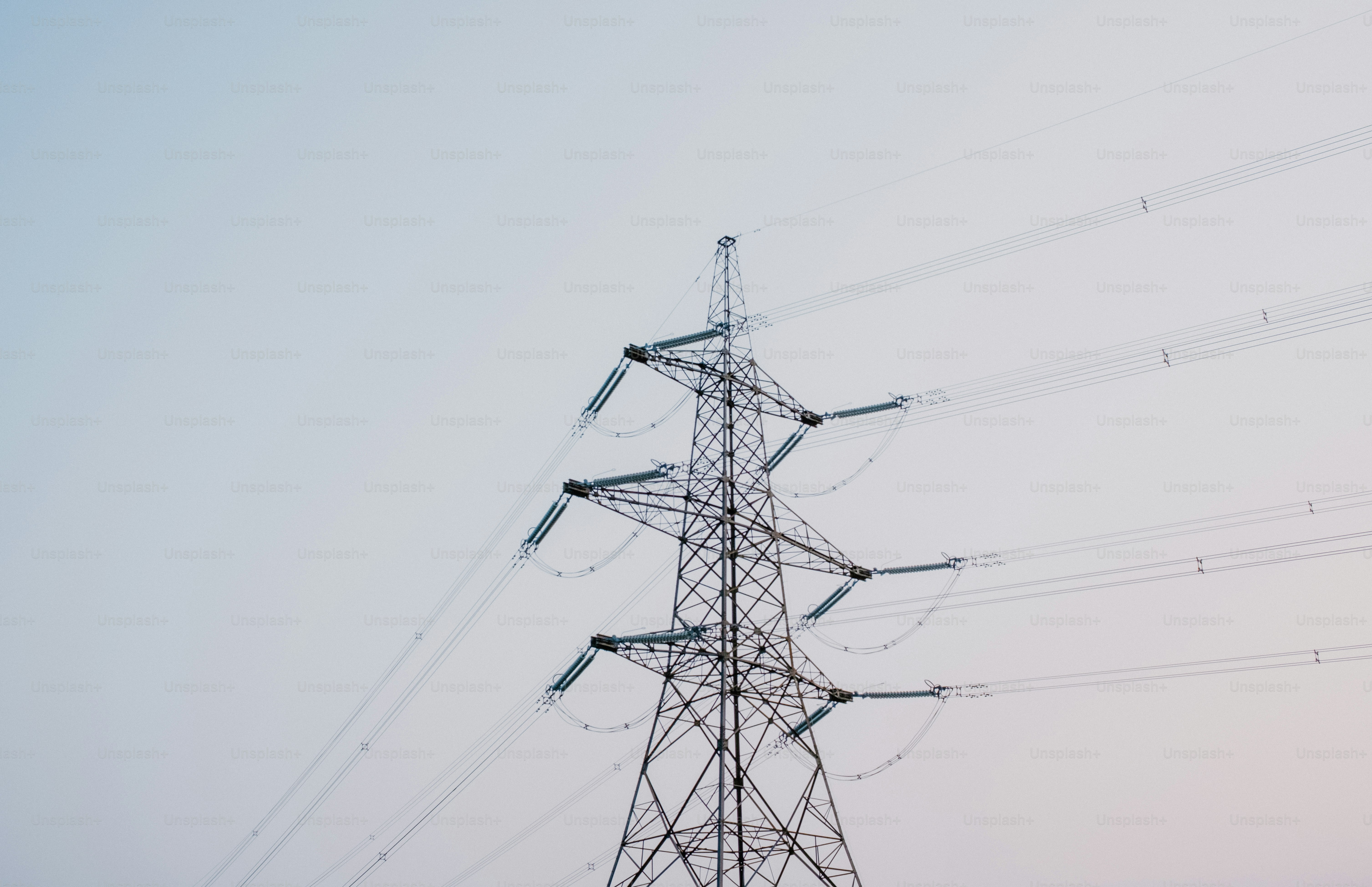 Power lines and a metal tower stretch into the sky