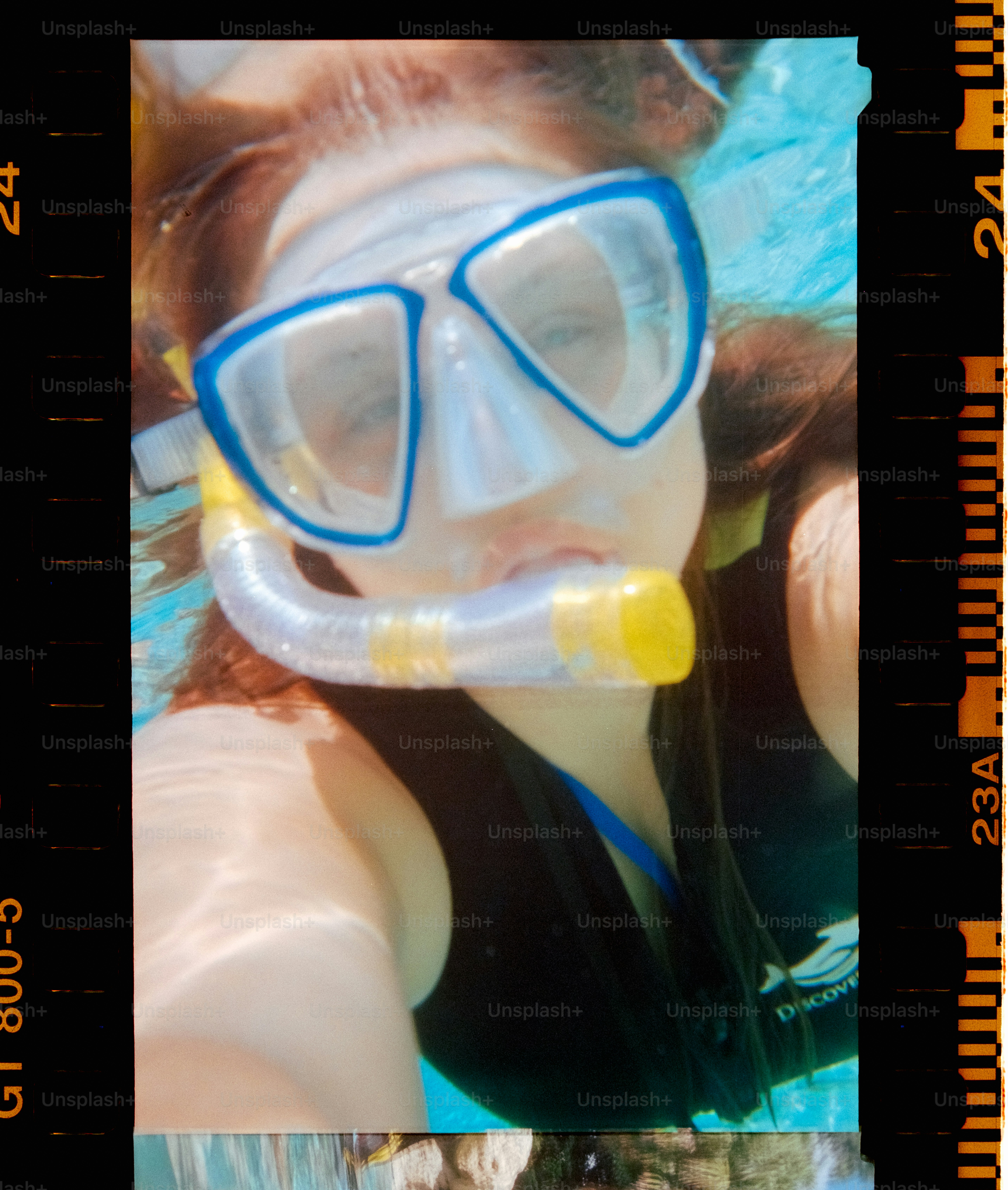 Woman snorkels underwater with a mask and snorkel.
