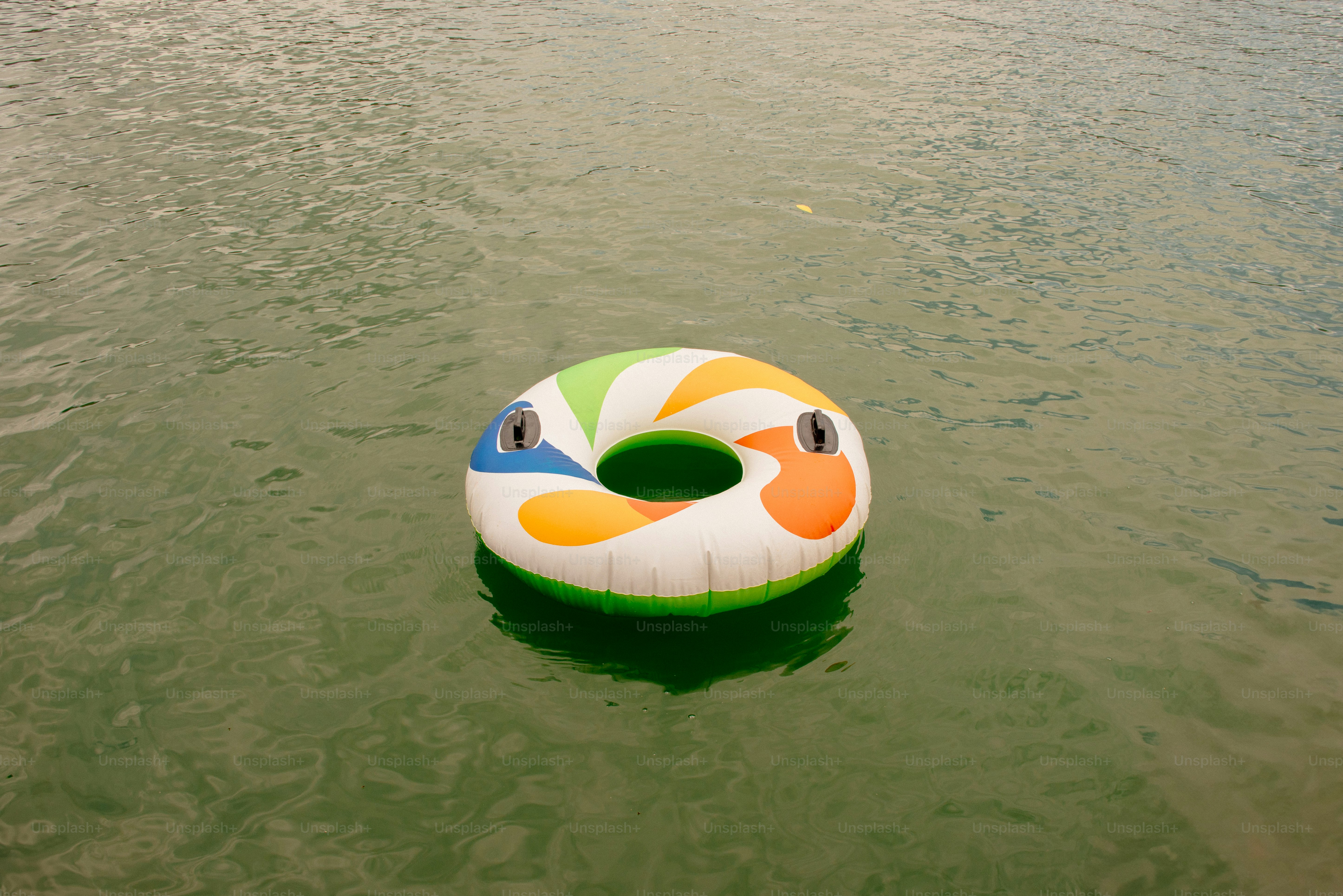 A colorful tube floats peacefully on water.
