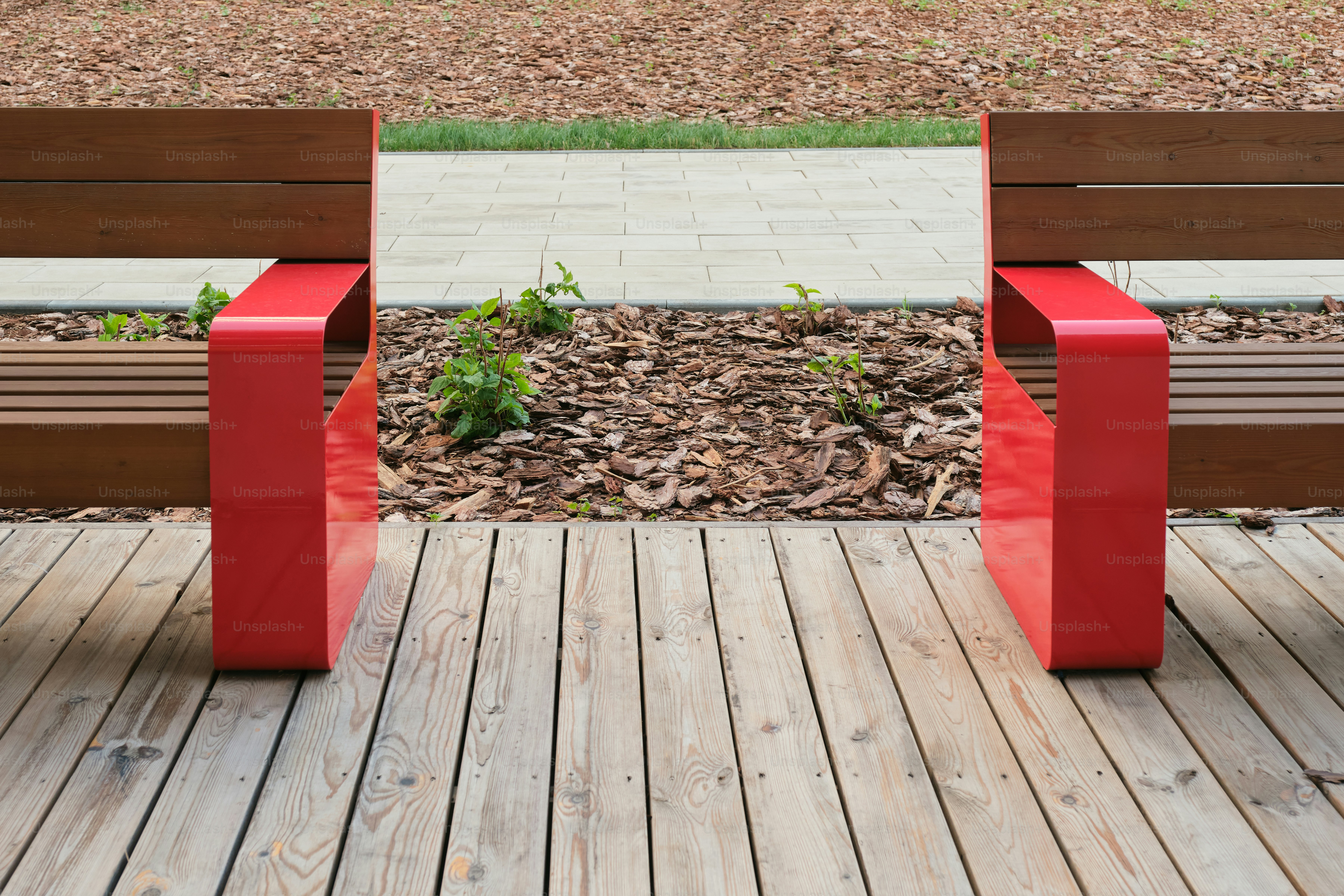 Two red armrests flank wooden benches.