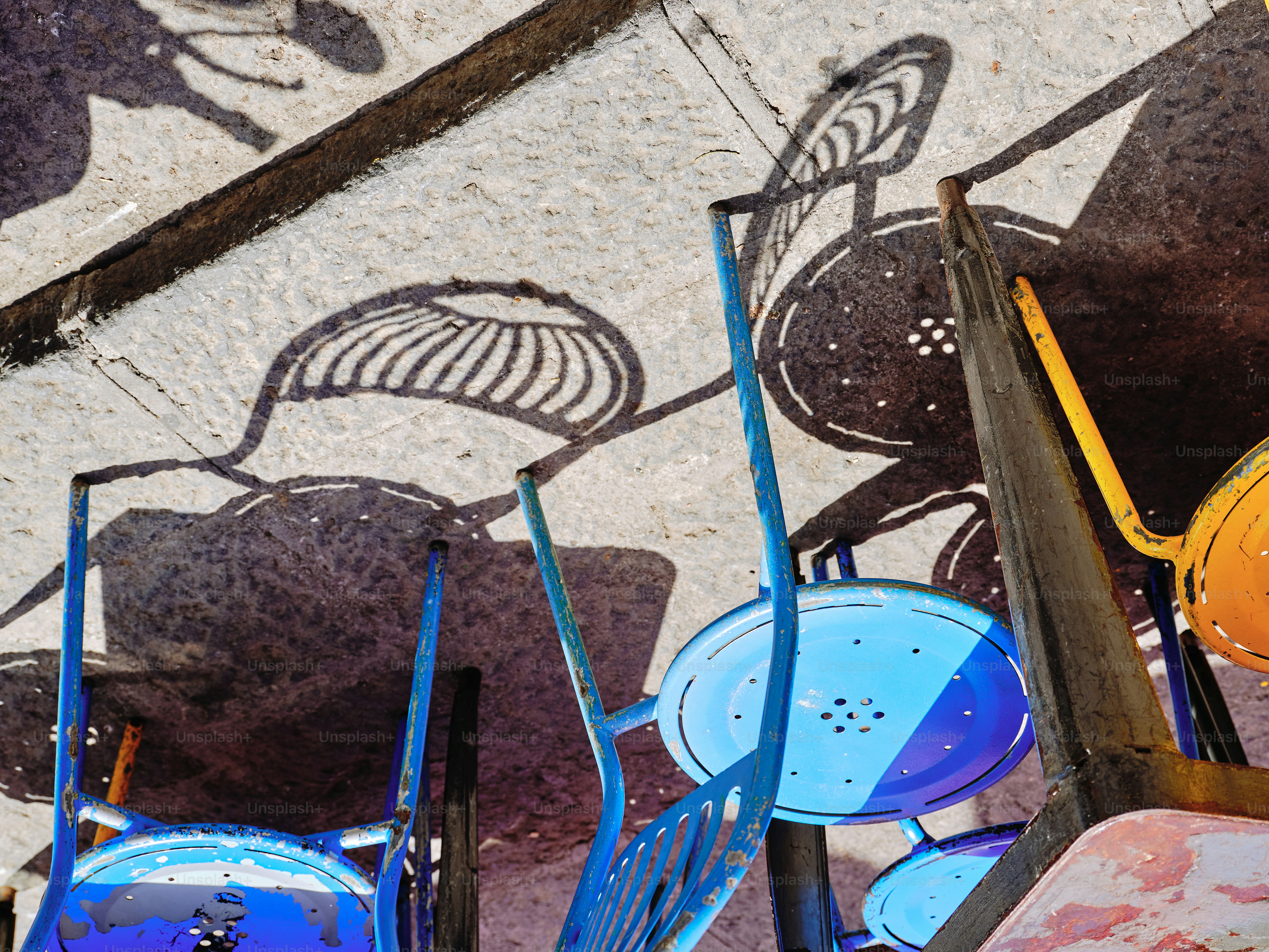 Les chaises projettent des ombres sur le béton.