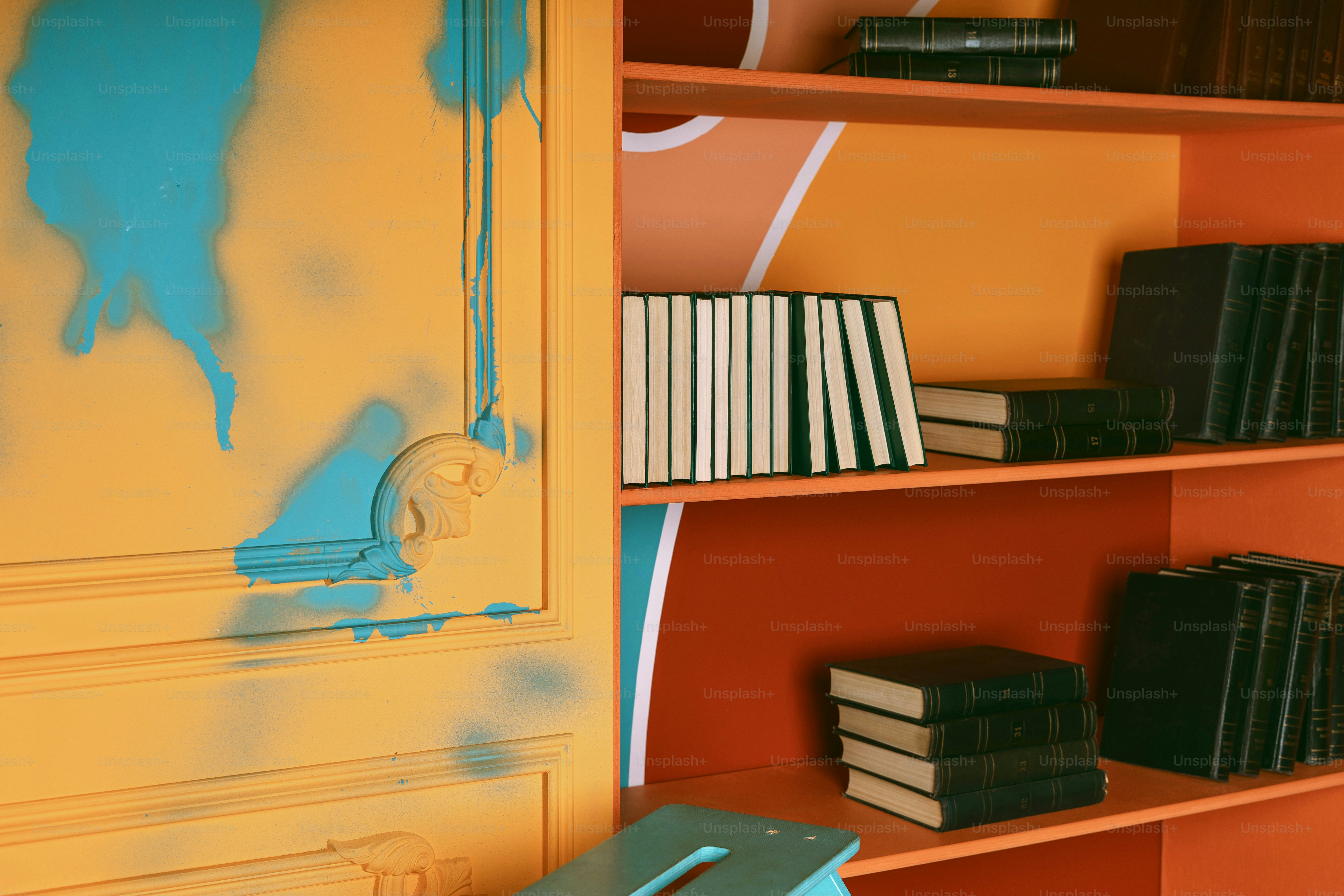 Bookshelves are filled with books and painted with bright colors.