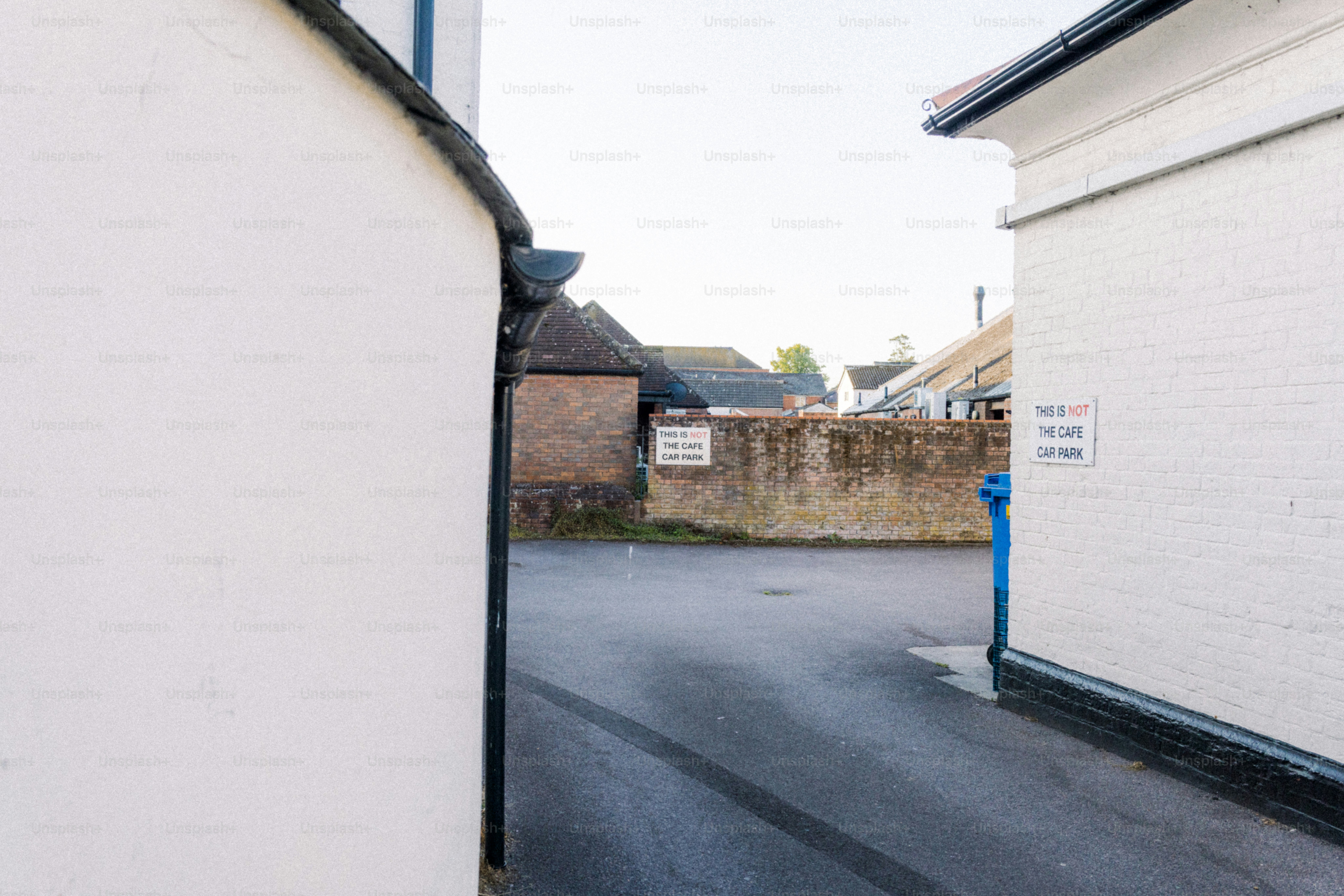 An alleyway is framed by white buildings.