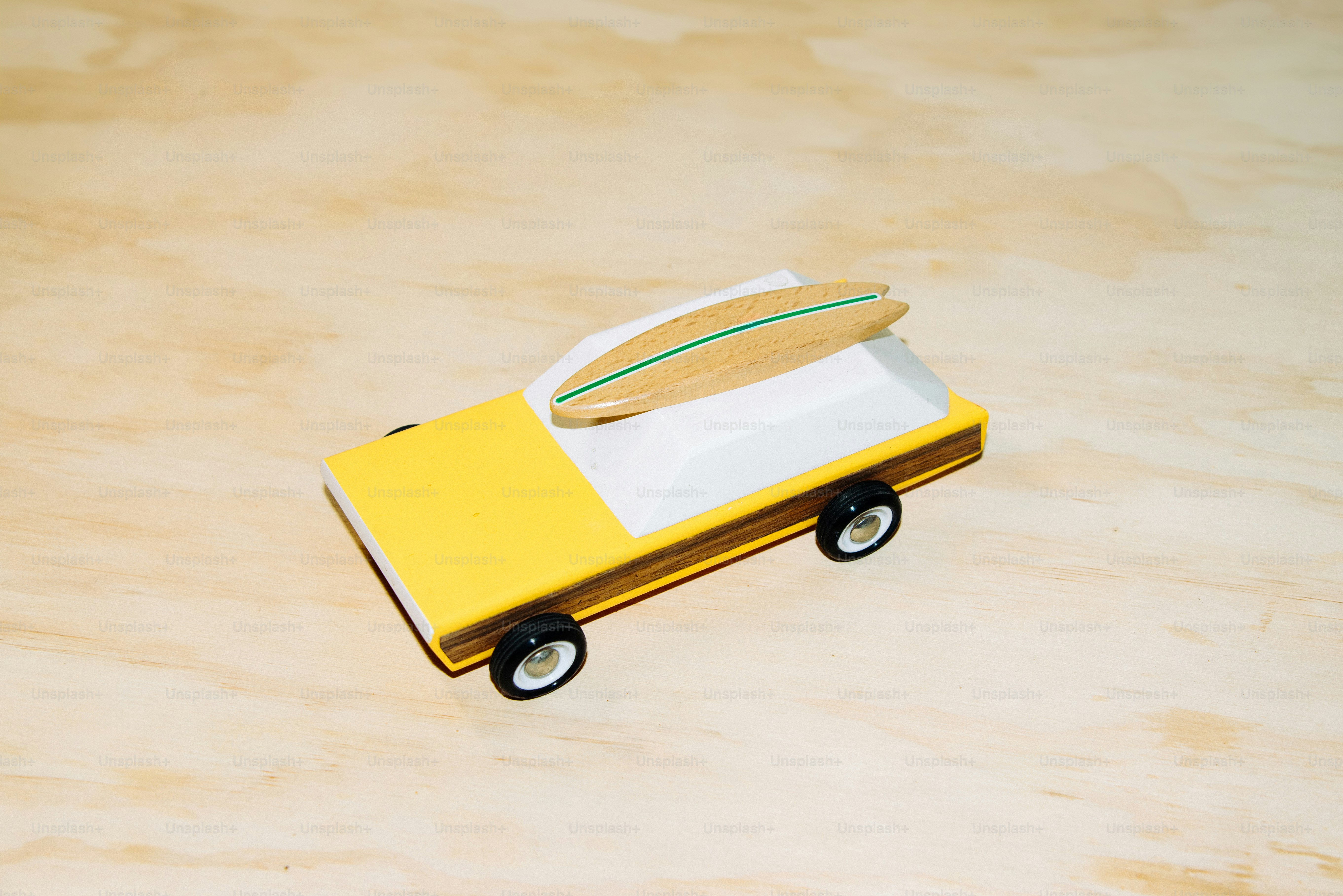 Um caminhão de brinquedo com uma prancha de surf em cima.