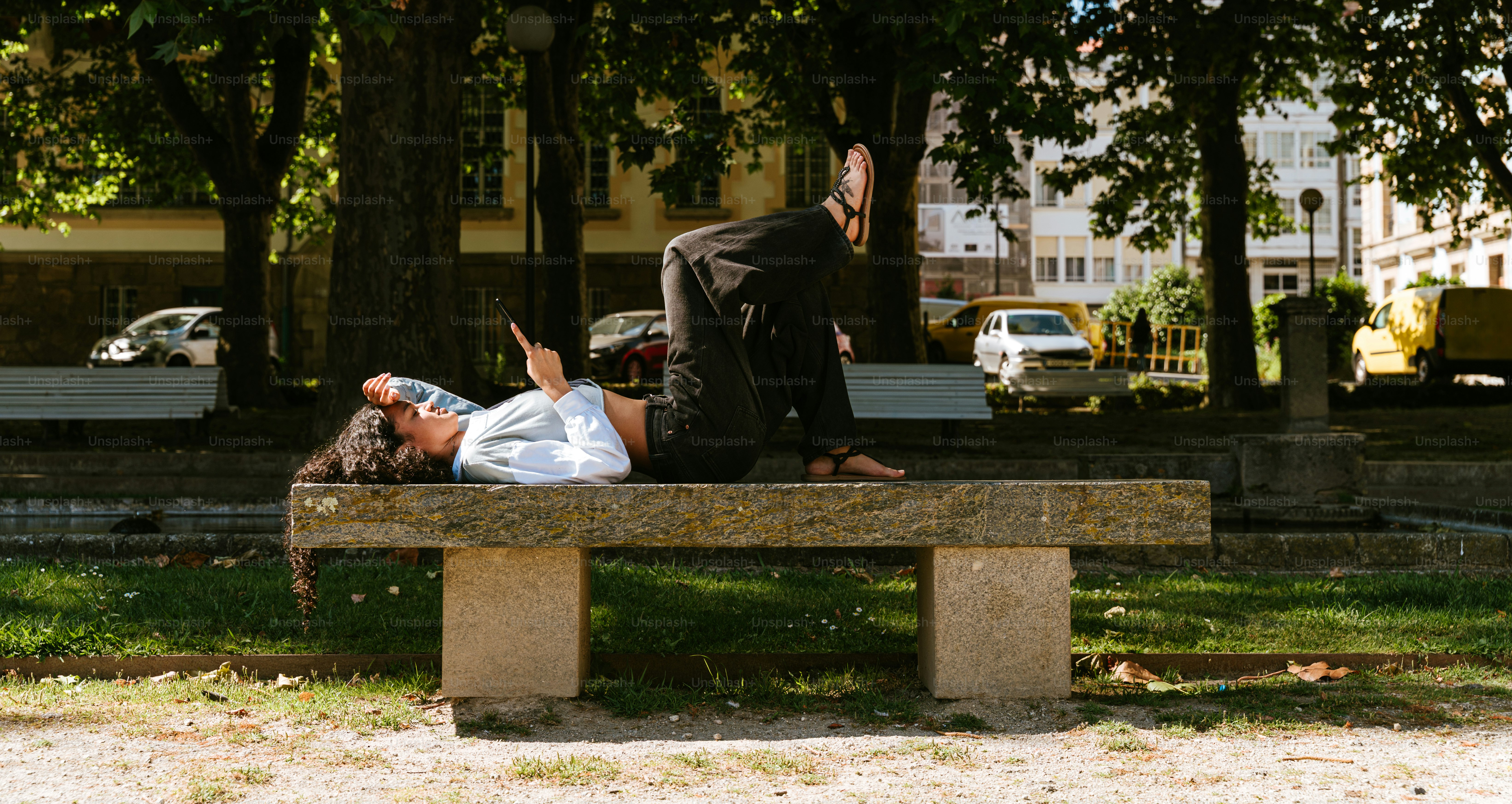 A woman is doing yoga on a bench.