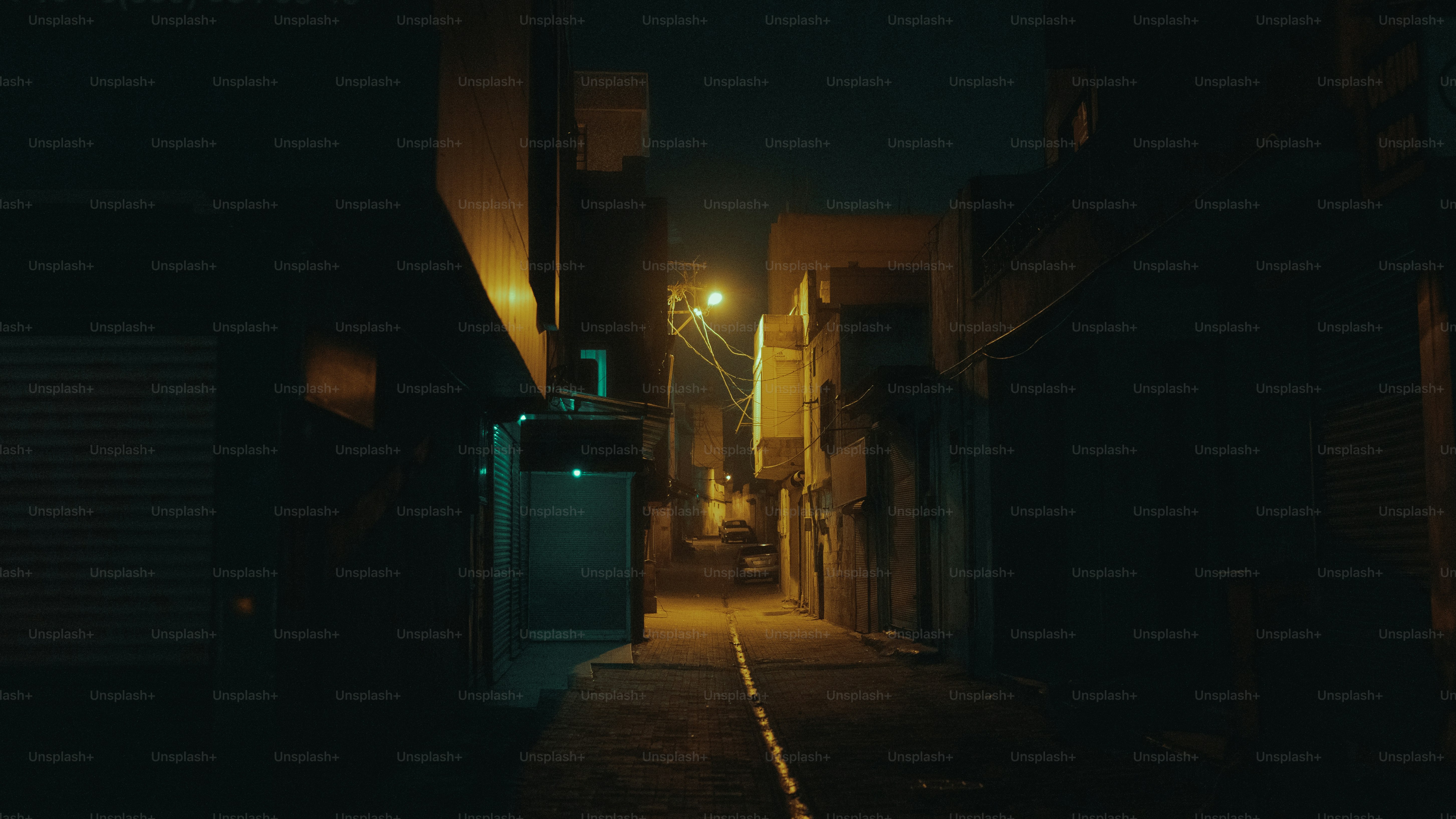 A quiet city street at night with a single streetlight, shadowy and tense atmosphere
