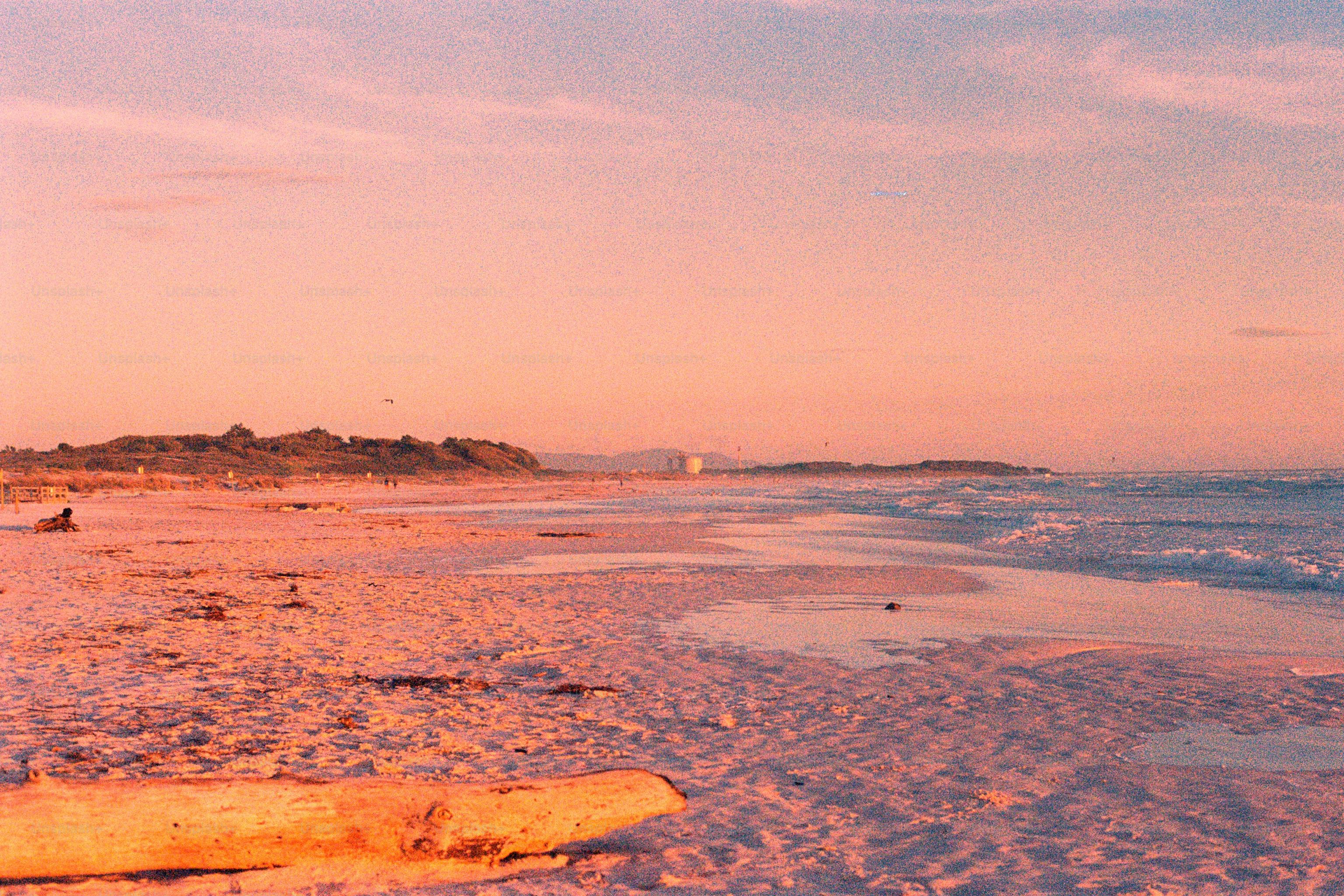 Un coucher de soleil rose brille sur la plage.