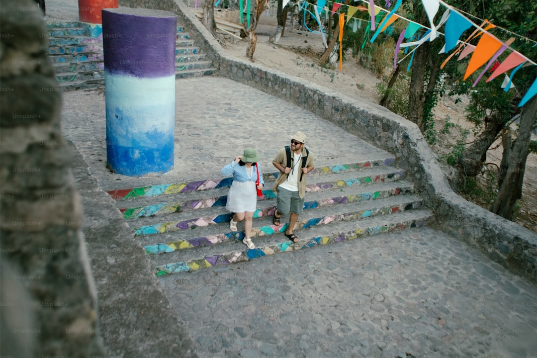 Two people walk down colorful outdoor stairs.