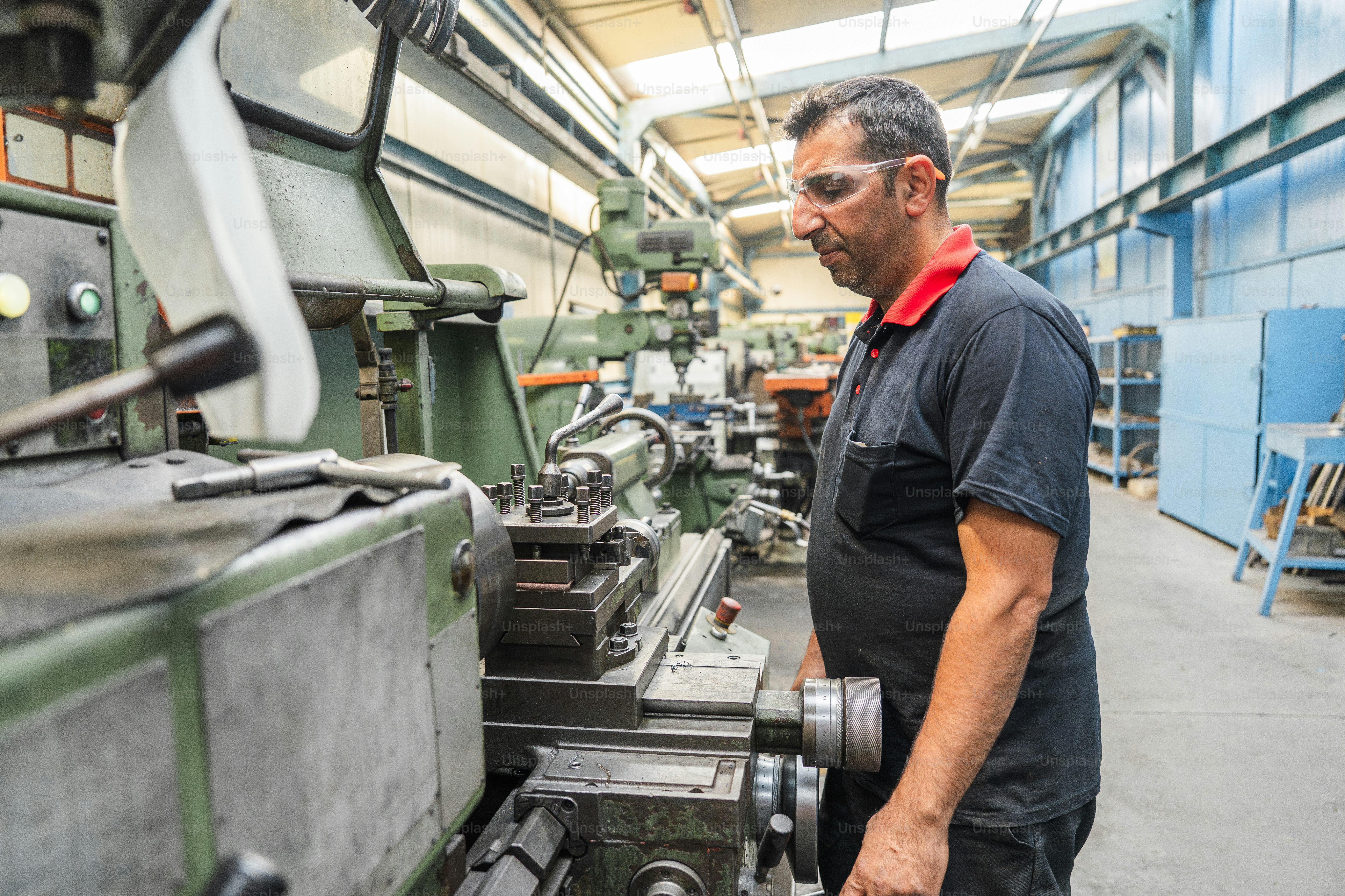 A machinist works on machinery in a workshop. photo – Manufacturing ...