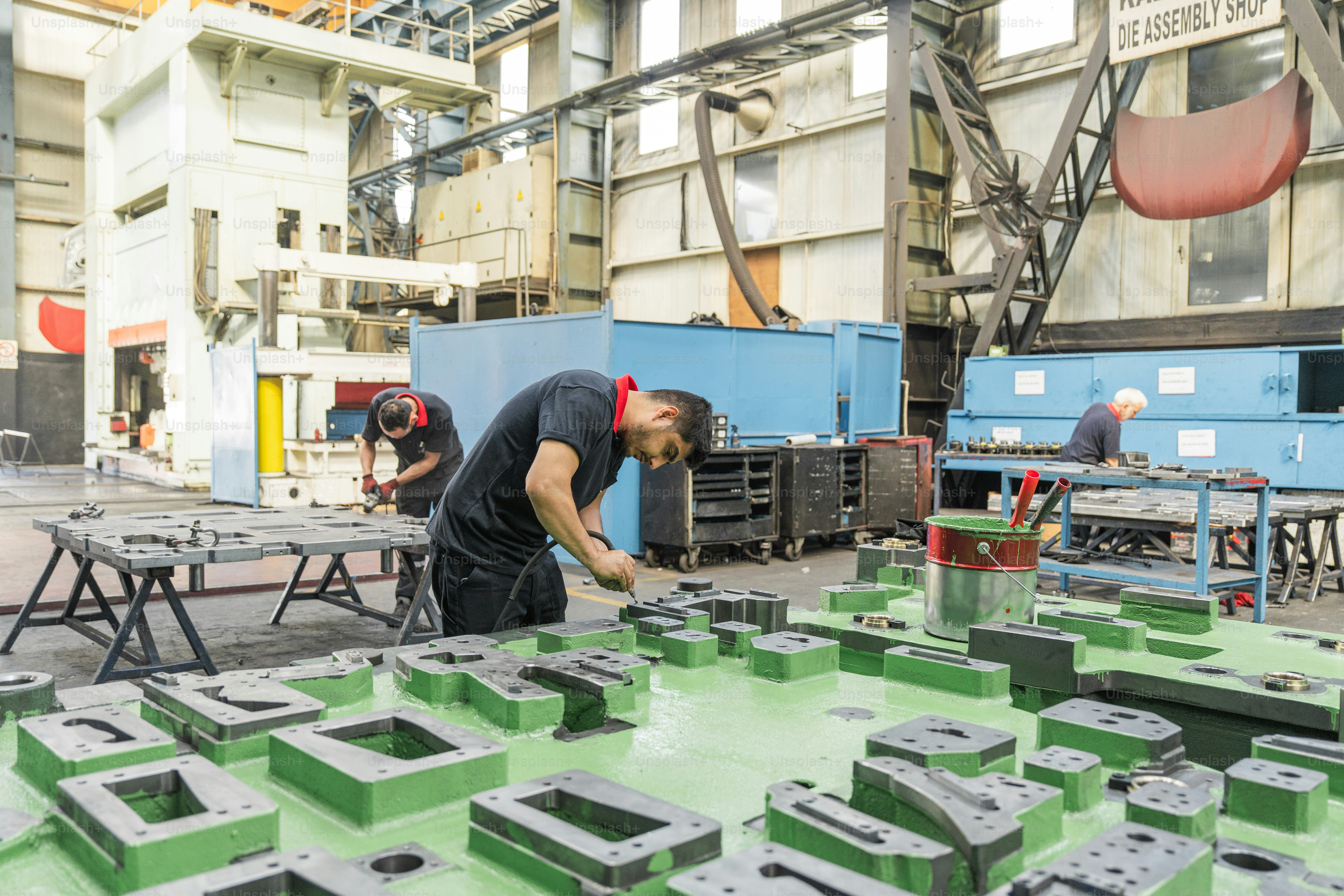 Workers are assembling metal parts in a factory. photo – Manufacturing ...