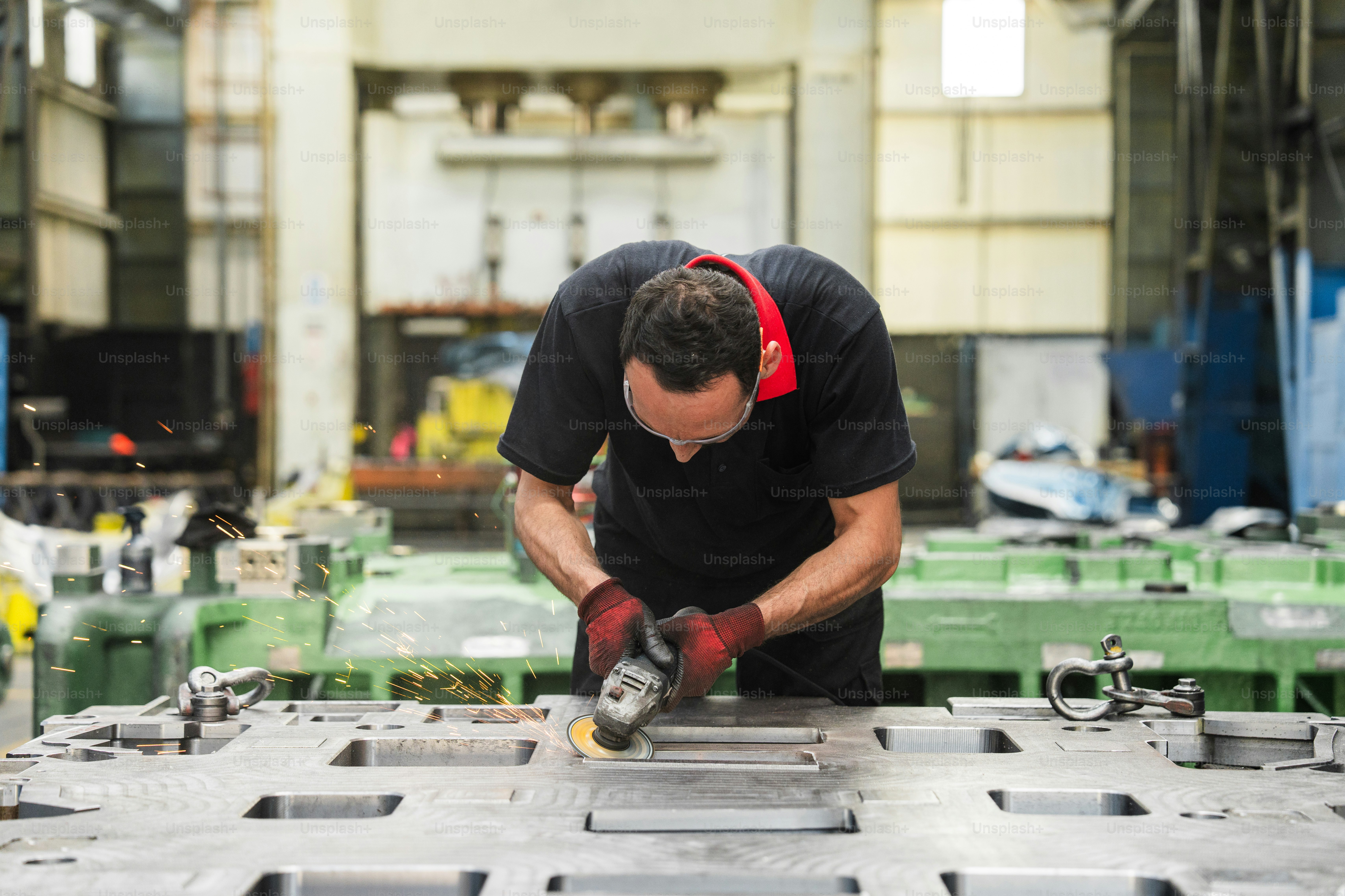Un homme utilise un broyeur dans une usine.