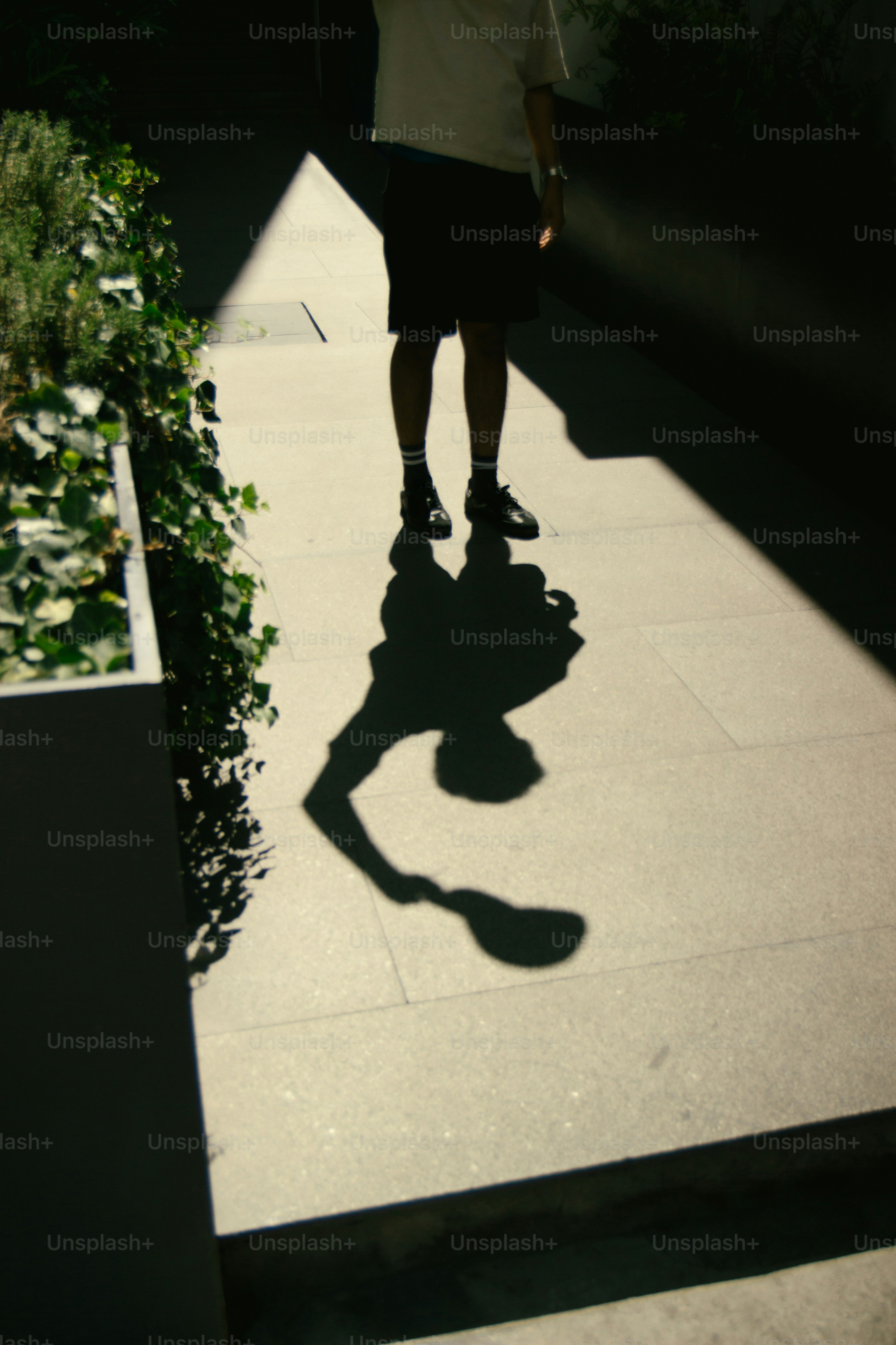 A man's shadow holds a racket