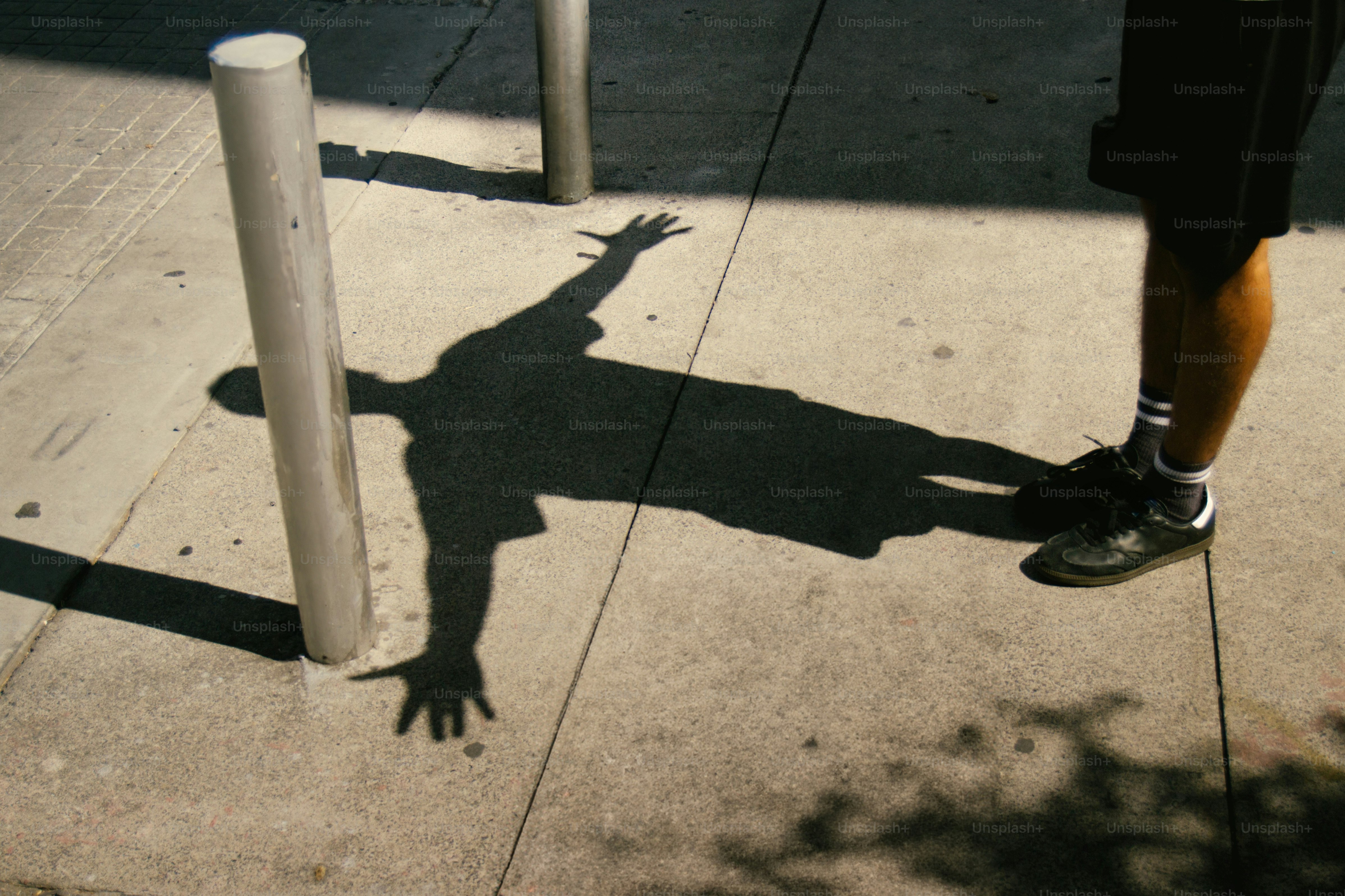 A shadow mimics a person pointing on the road. photo – Abstract Image ...