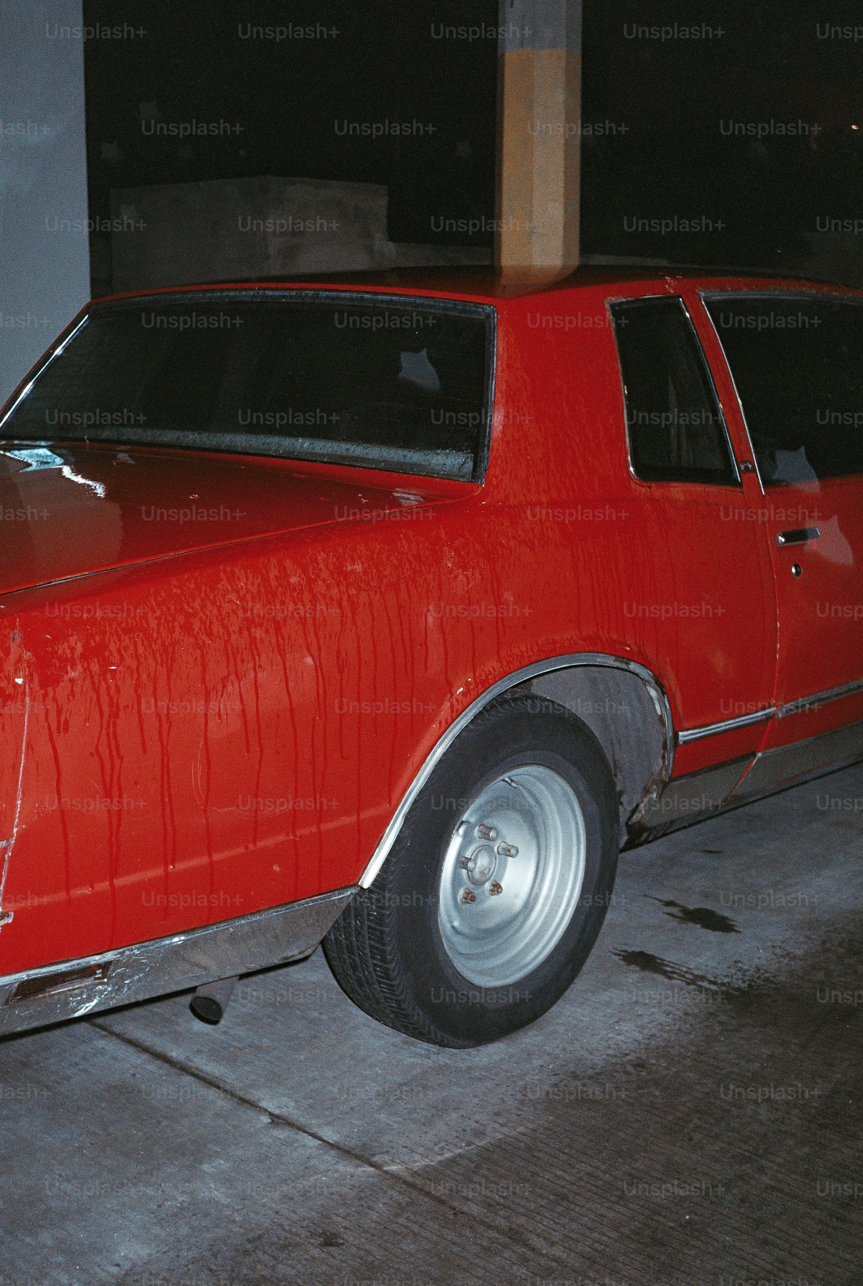 A red car is shown in a dark setting.
