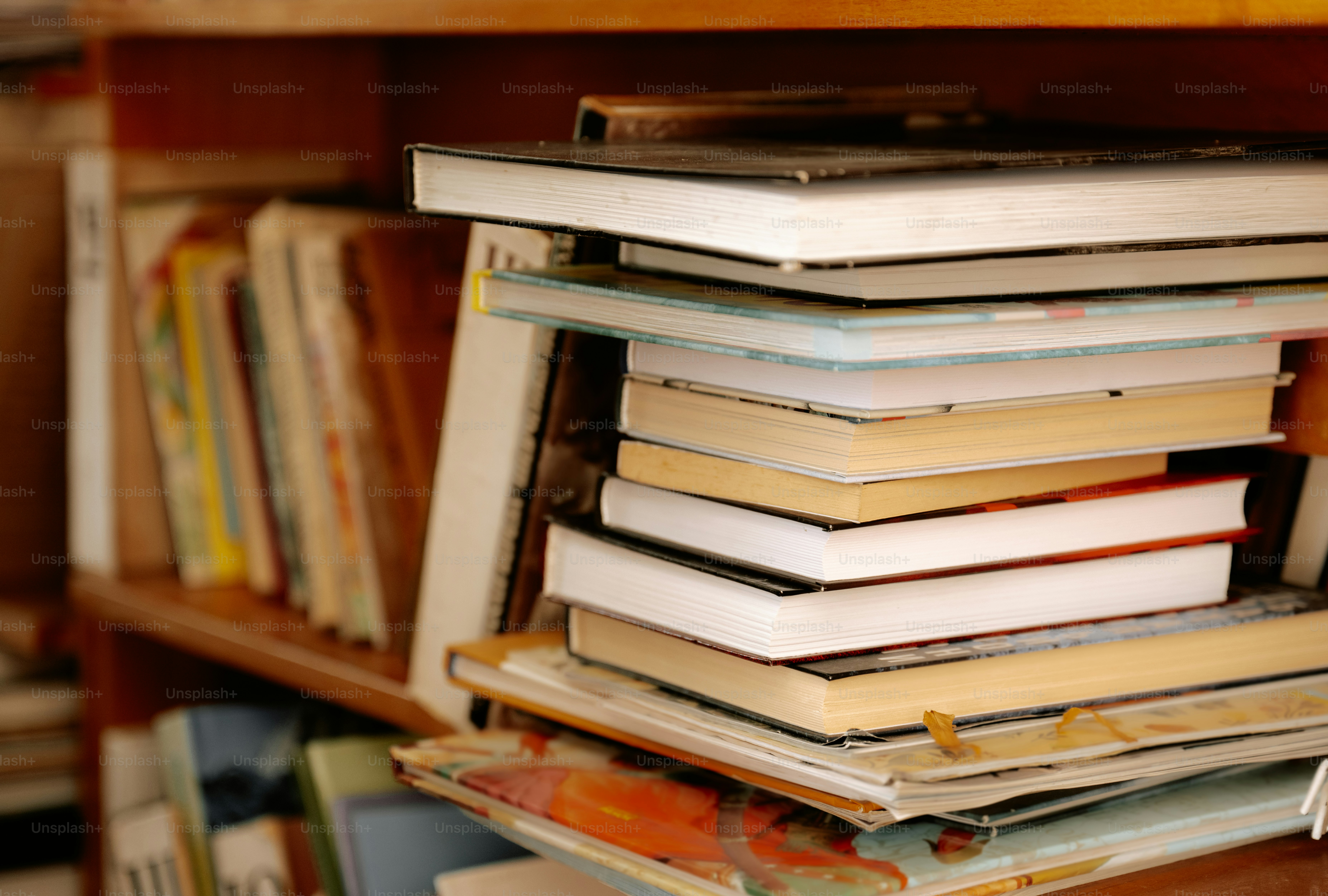 Books are stacked on a bookshelf.