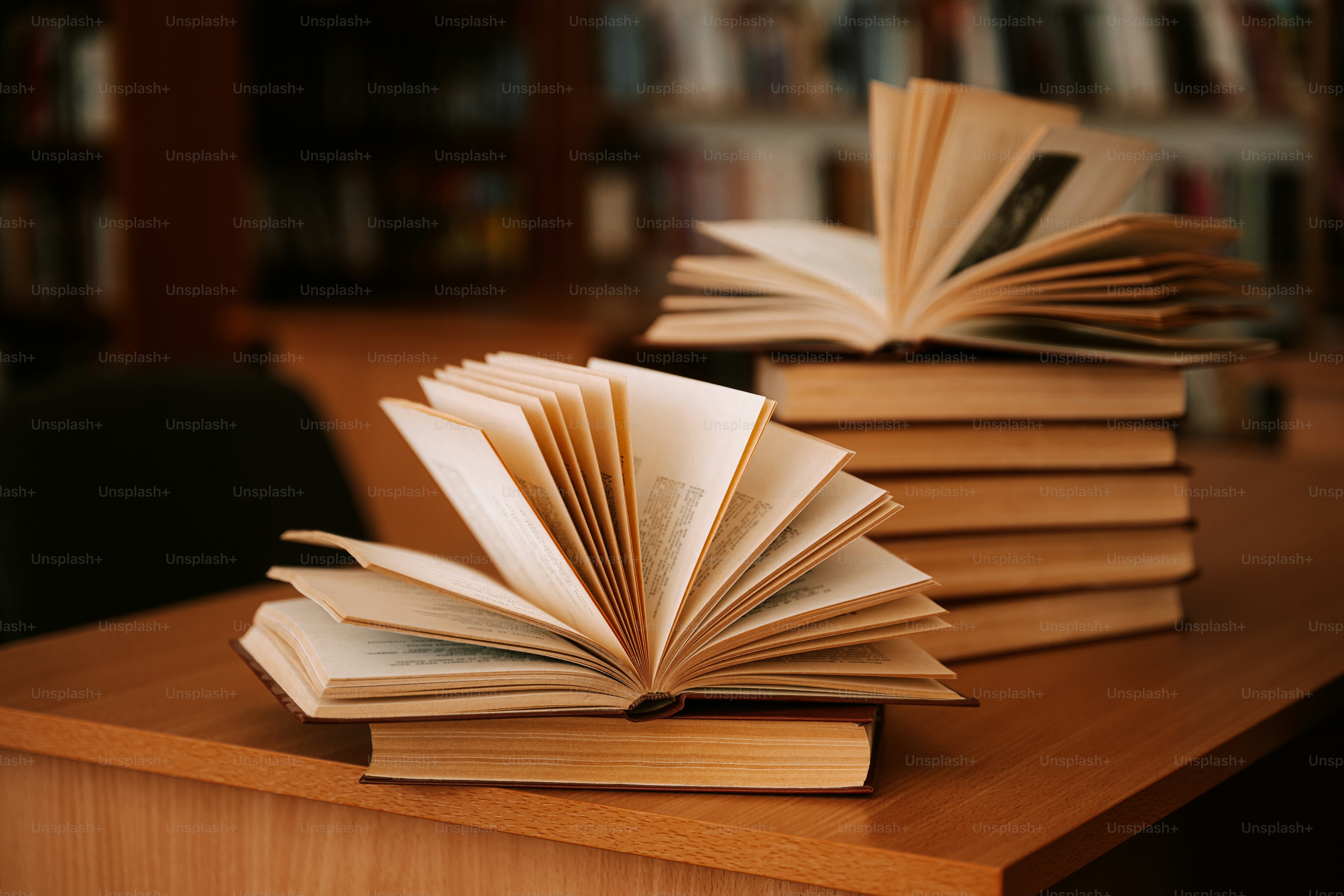 Open books rest on a wooden desk.